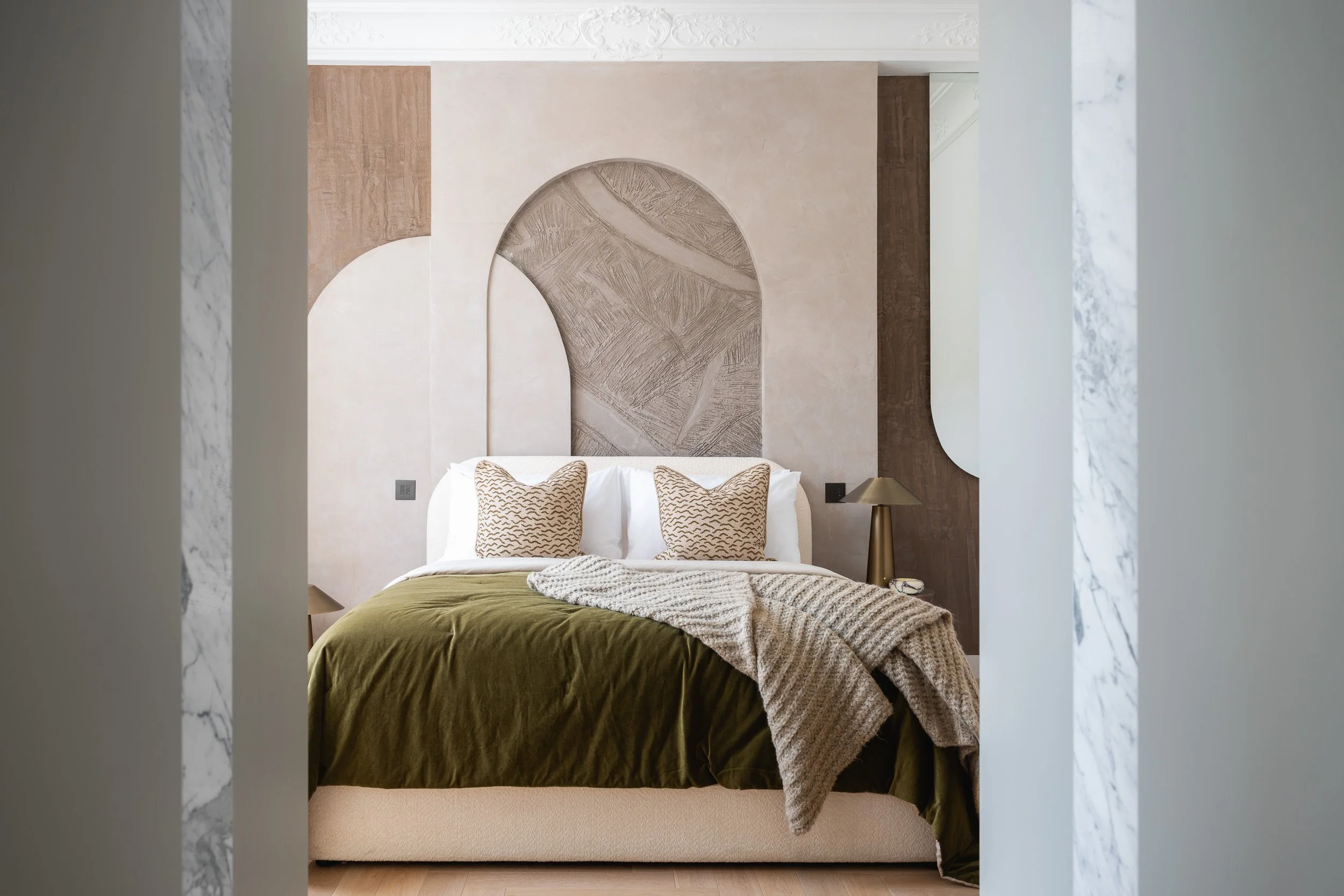 Bedroom with a green bed throw and upholstered headboard