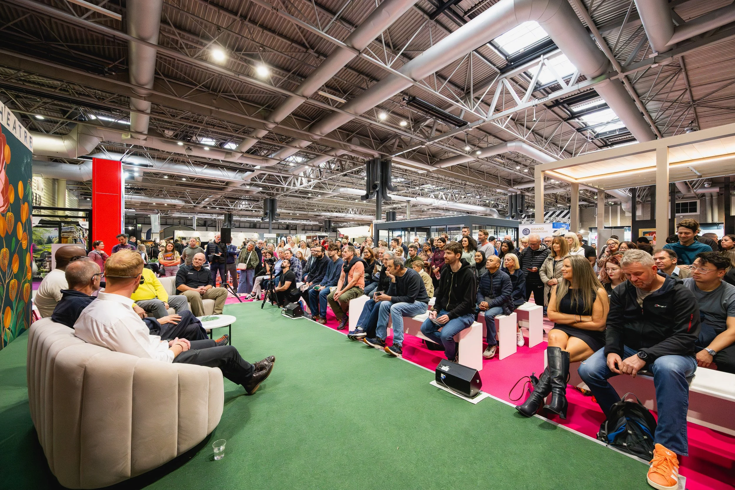 Seated audience watching a discussion at Grand Designs Live at the NEC Birmingham.