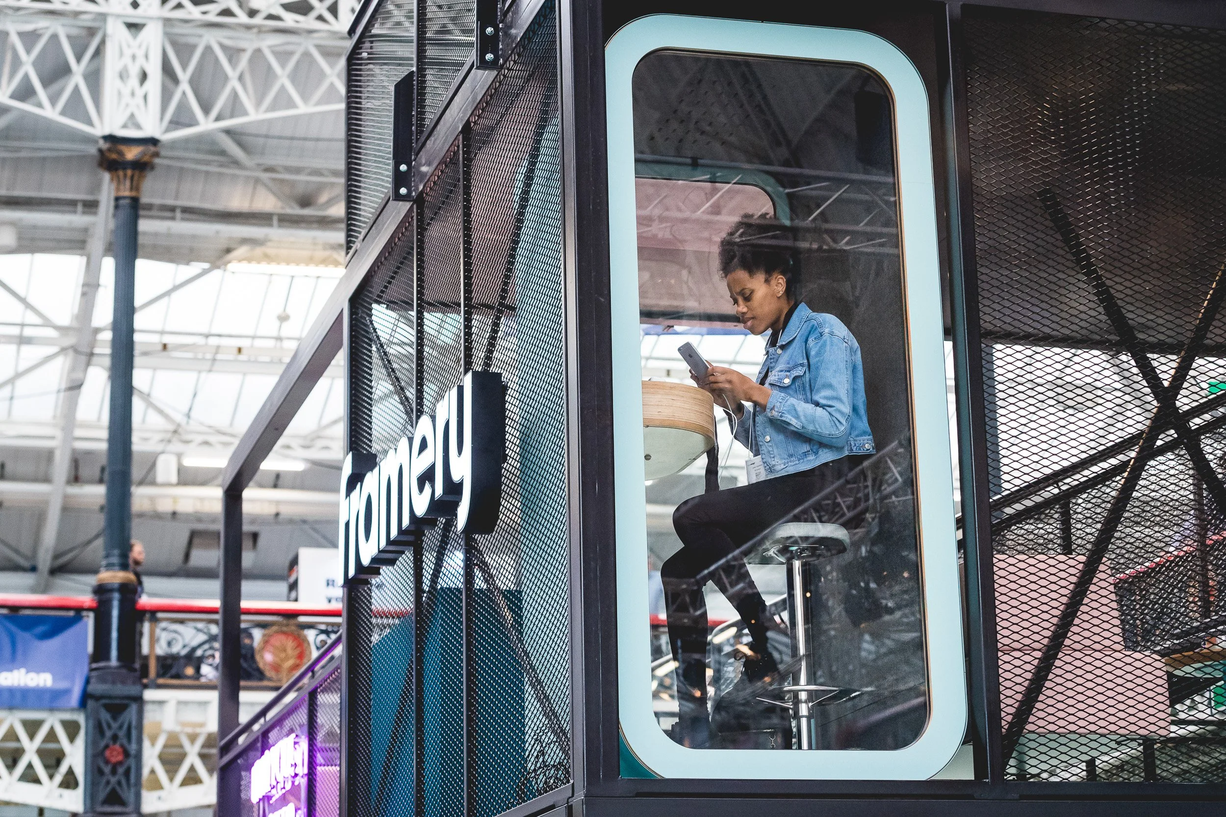 A visitor seated inside a Framery pod on an exhibition stand.