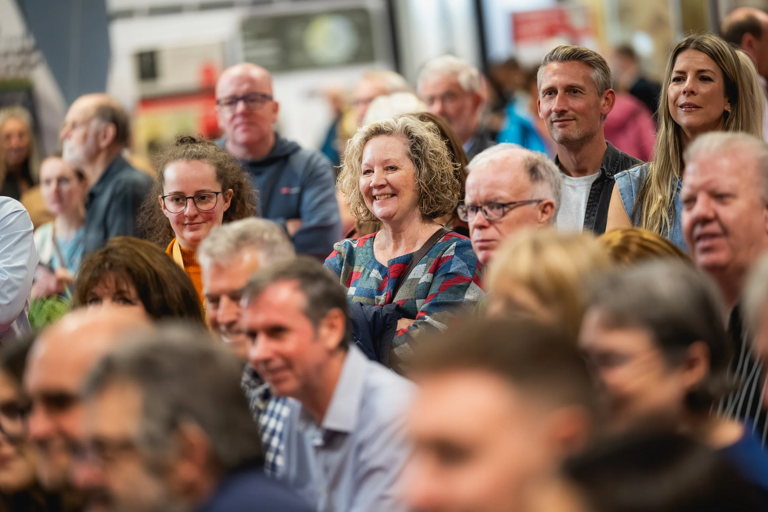 Audience members smiling and laughing during a Grand Designs Live session.
