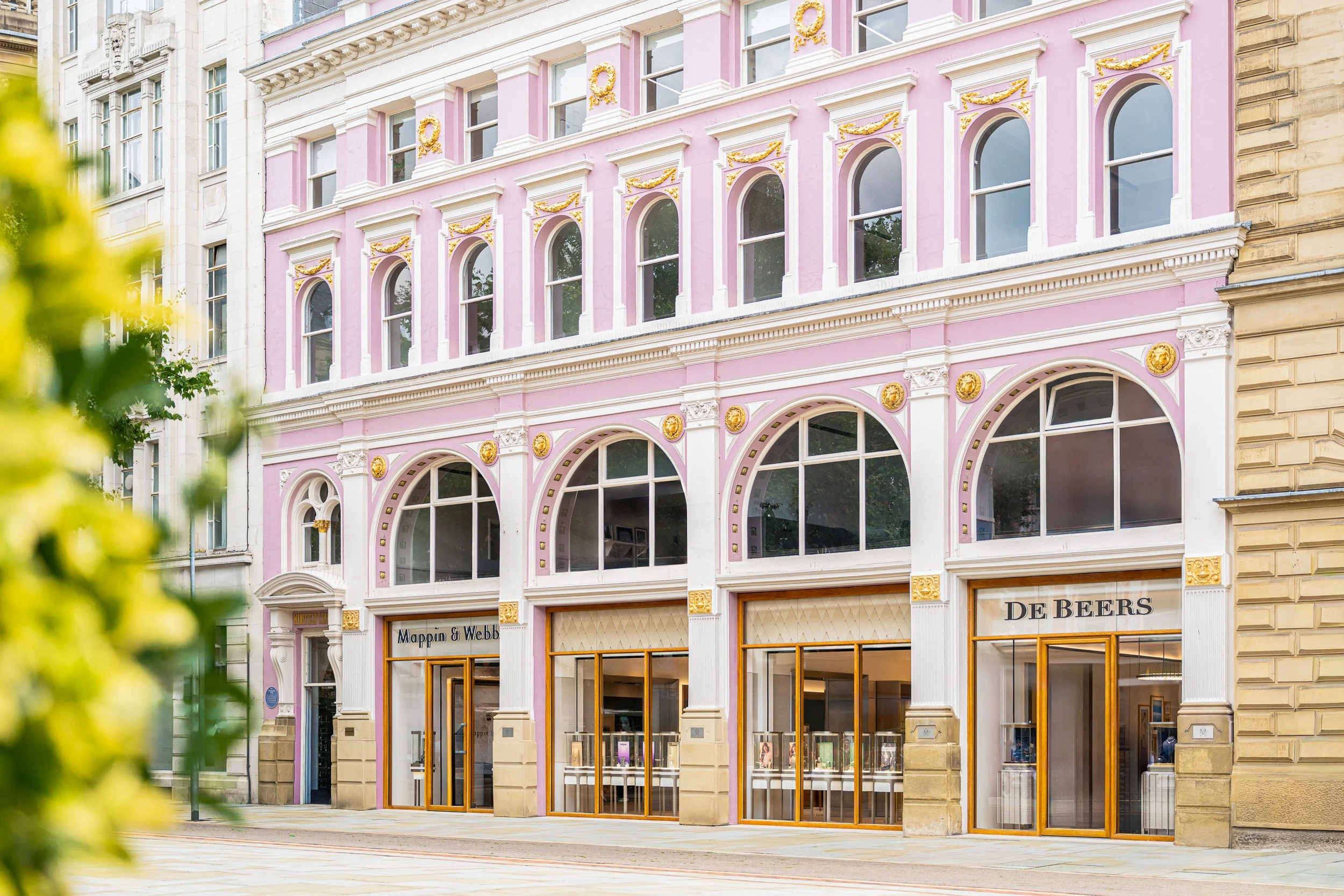Pink and white Mappin & Webb façade with arched windows and gold-coloured entrance frames.