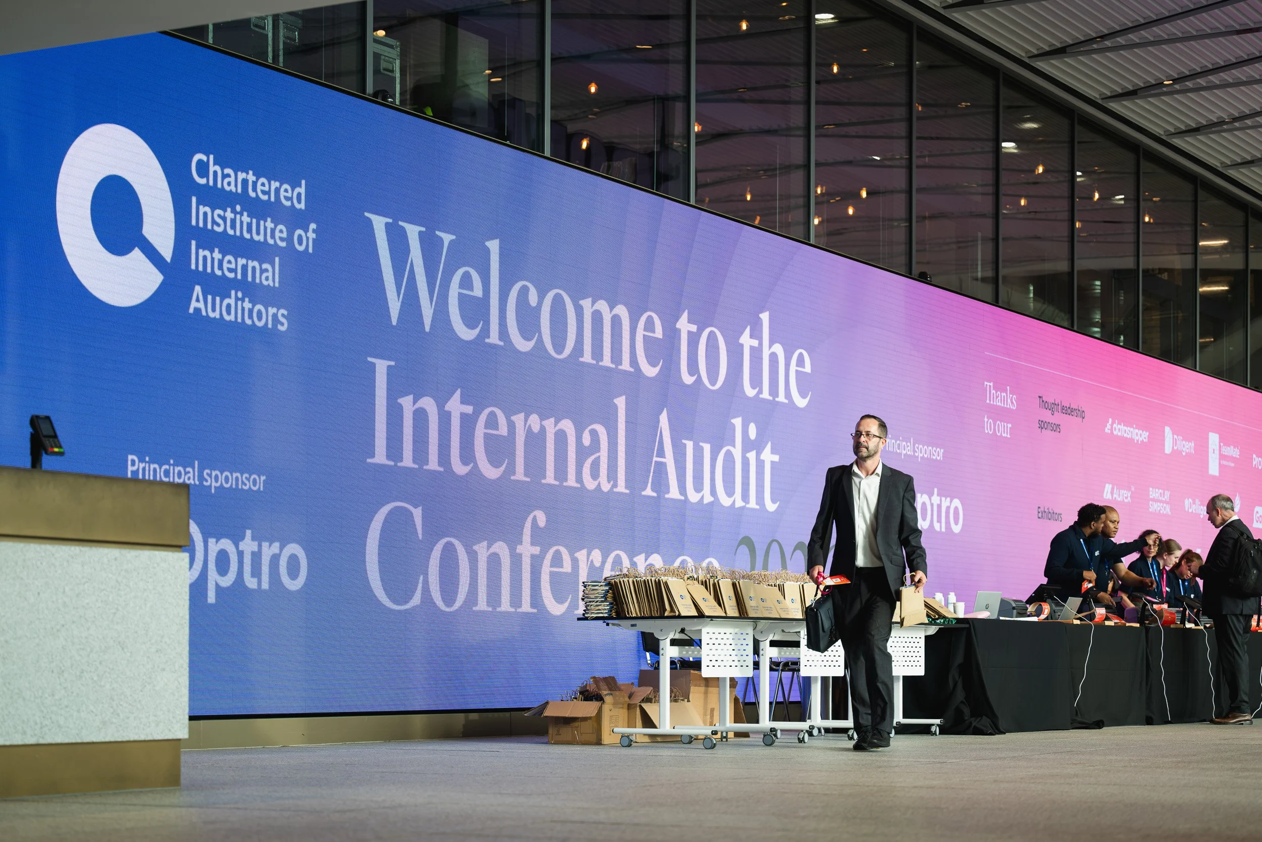 Speaker on the main stage beneath the Internal Audit Conference screen.