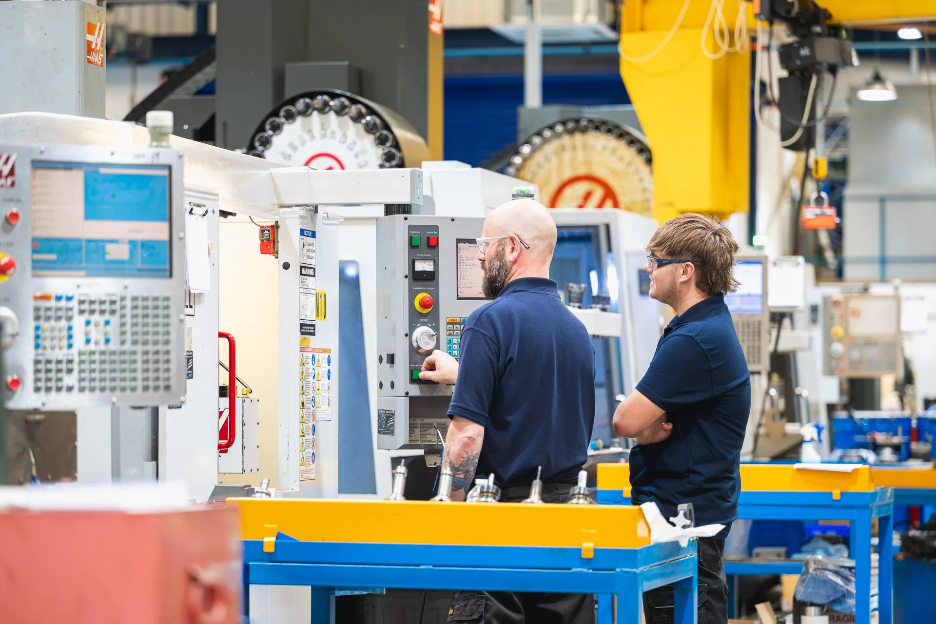 Two colleagues beside machinery on the factory floor at WLR Precision Engineering in Nottingham.