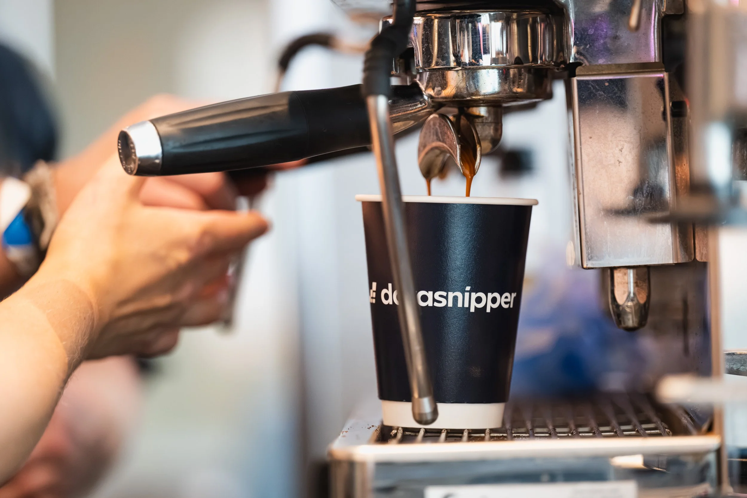 Coffee being dispensed into a DataSnipper branded cup at the conference.