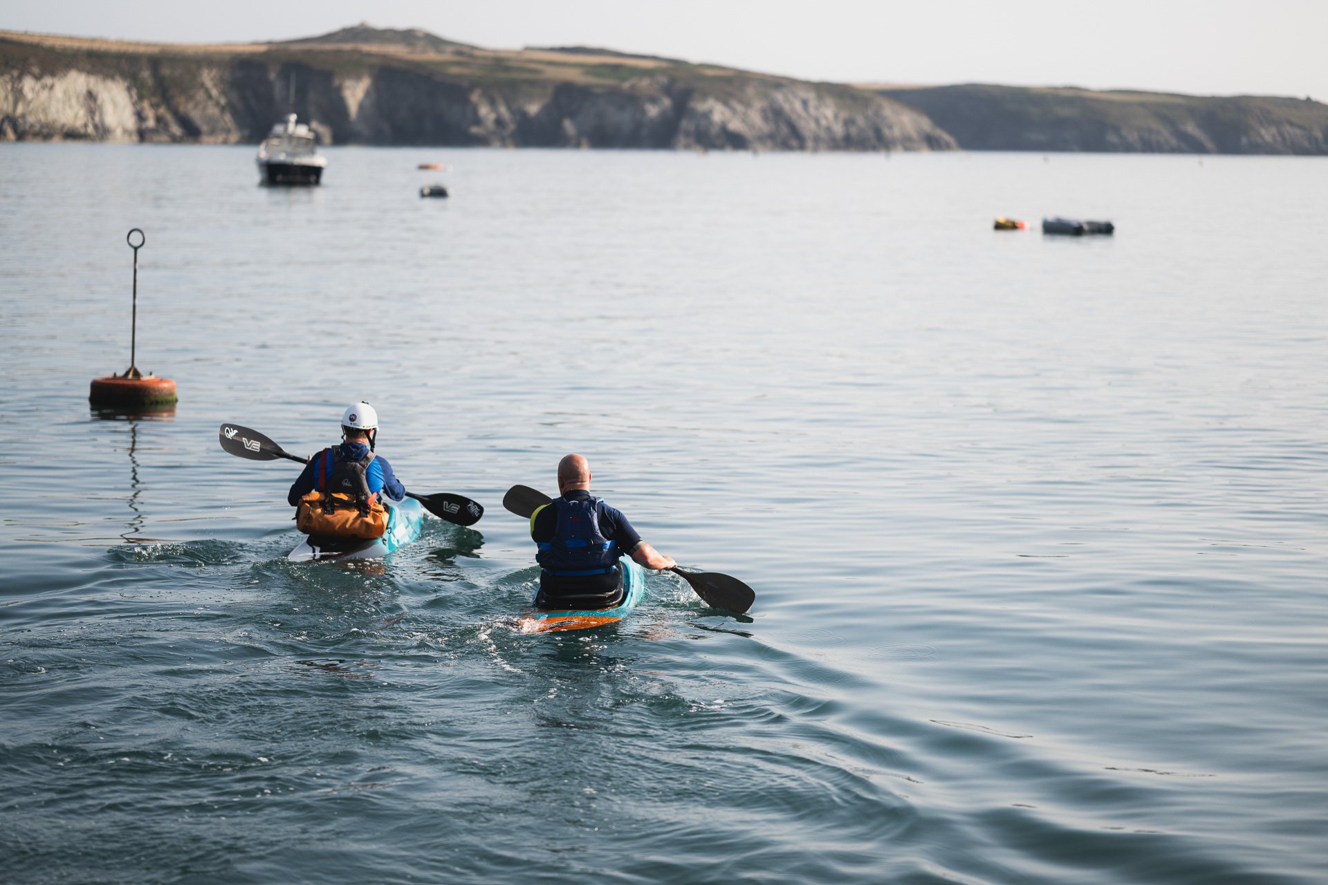Two people travelling across the water towards the seaweed farm.