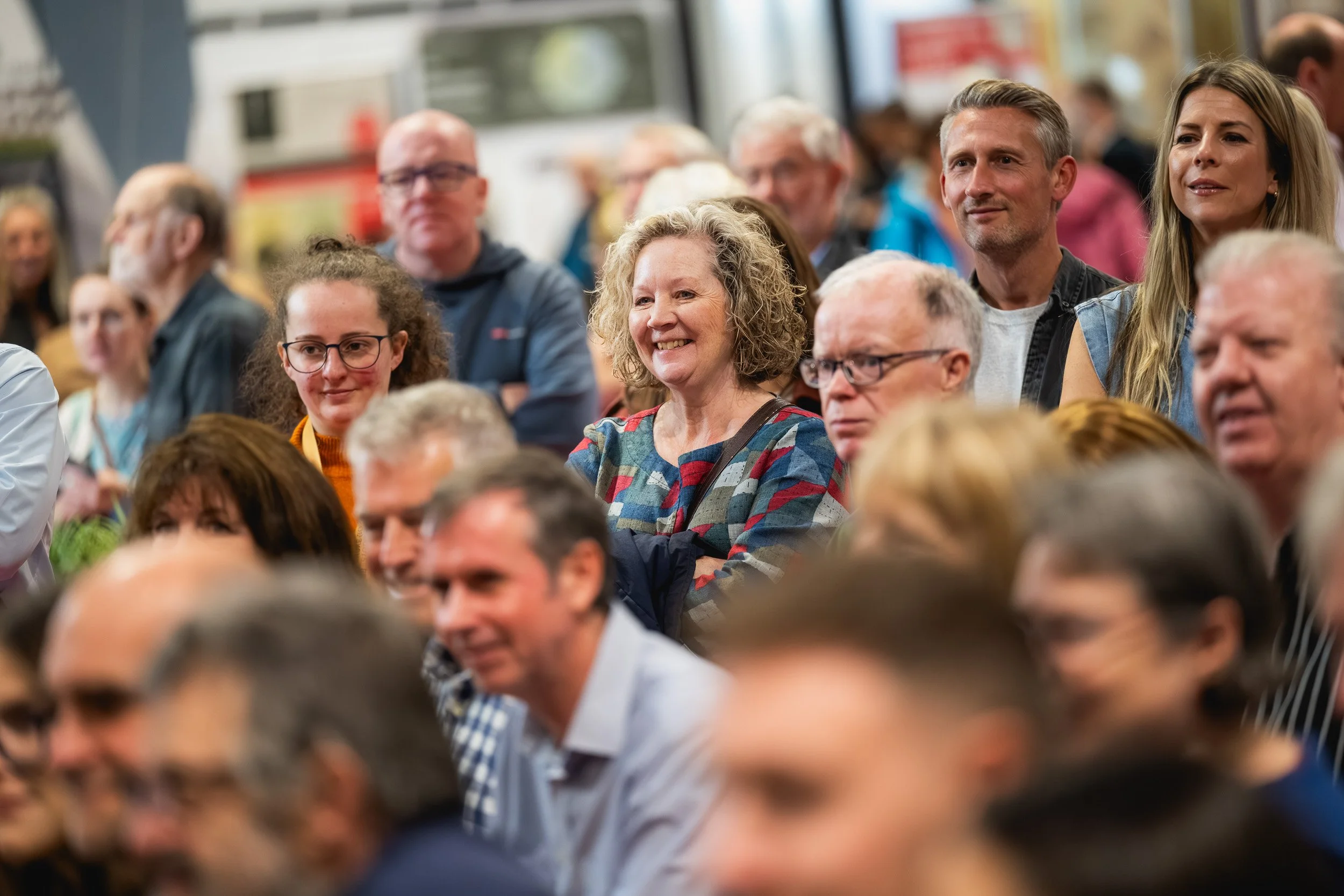 Audience members smiling and laughing during a Grand Designs Live session.