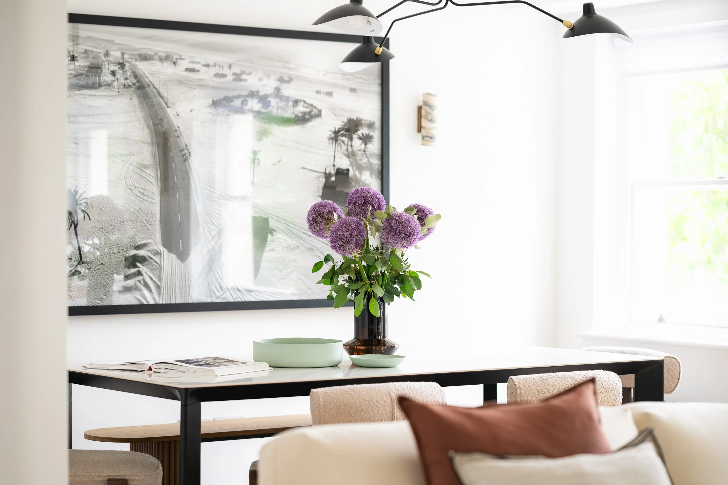 Dining area with framed artwork and flowers