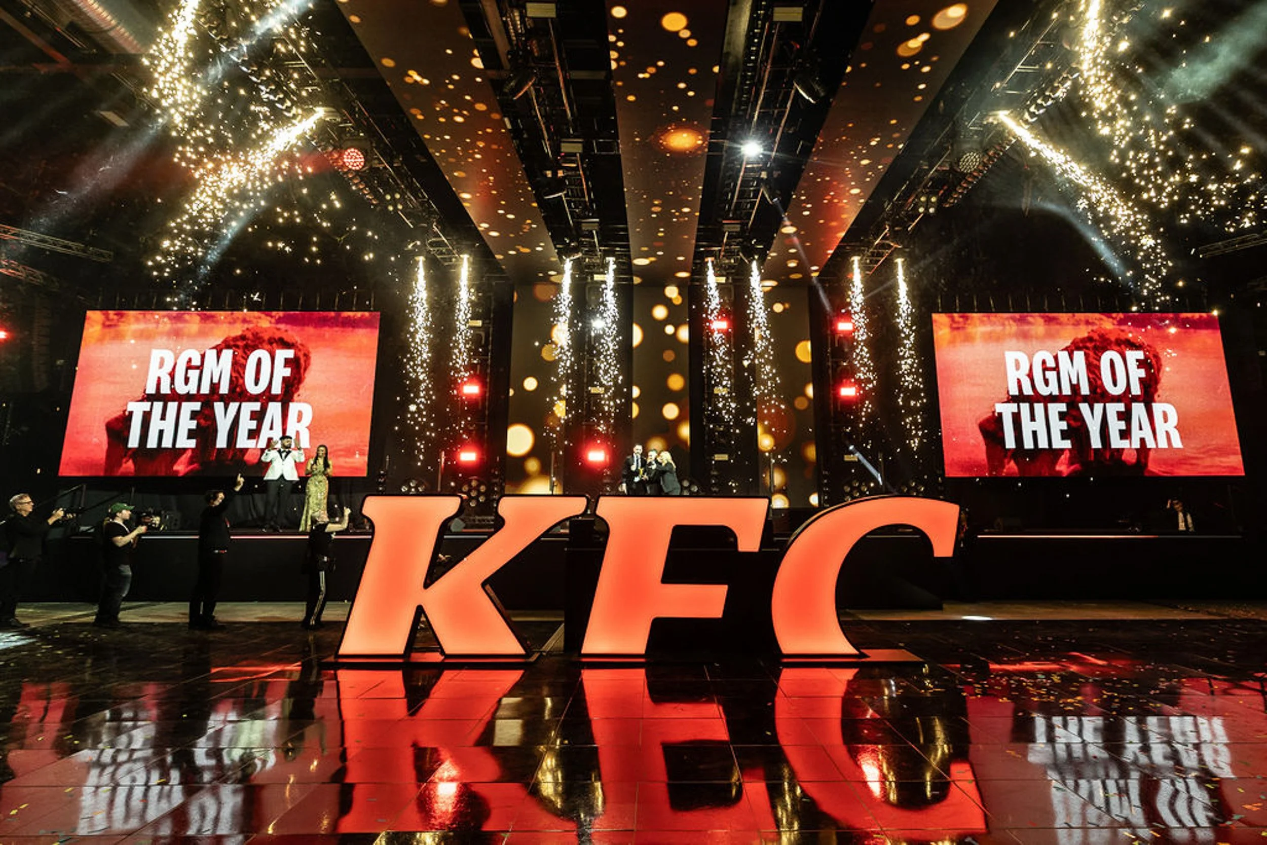 Sparks cascading above the KFC awards stage, with RGM of the Year on the screens.