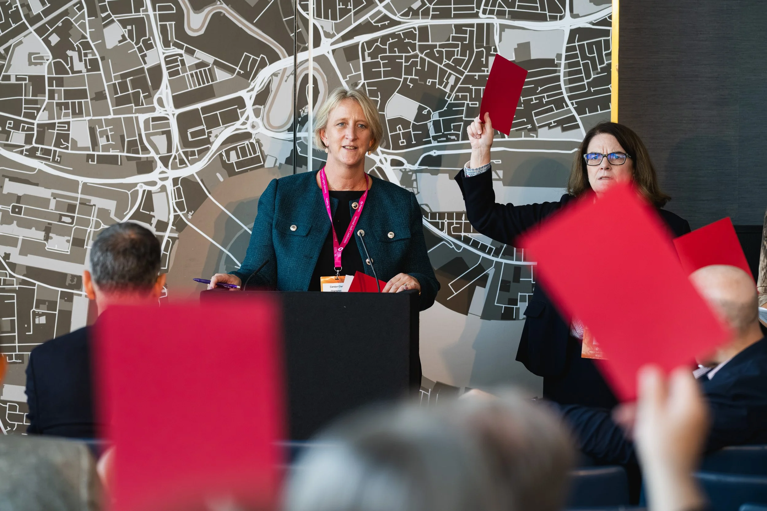 Conference delegates raising red cards during an interactive session.