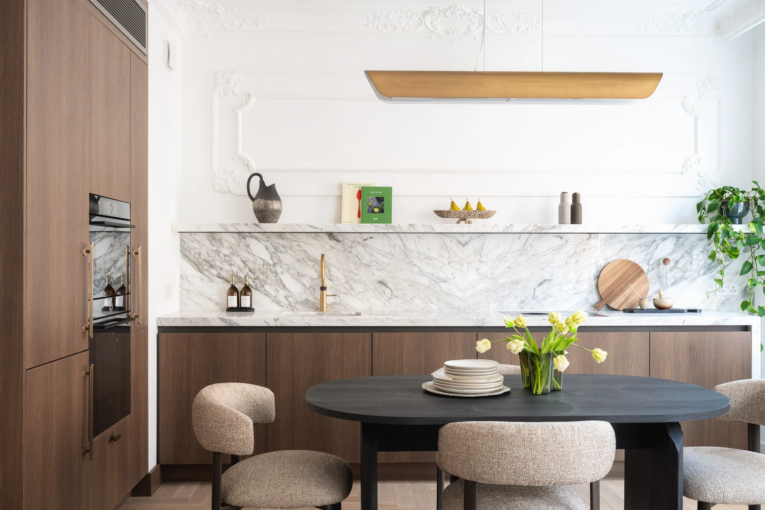 Timber kitchen and round dining table in a bright residential interior