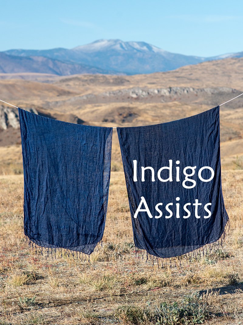 Two linen shawls dyed dark blue, with the caption "Indigo Assists."