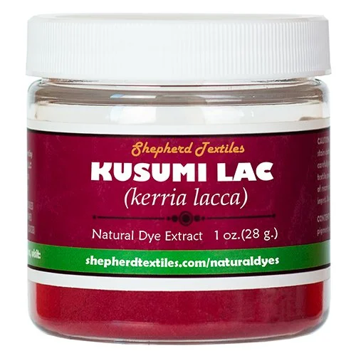 A plastic jar full of red powder labeled "Kusumi Lac".