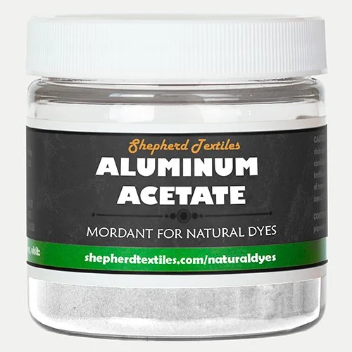 A plastic jar filled with white powder labeled "Aluminum Acetate."