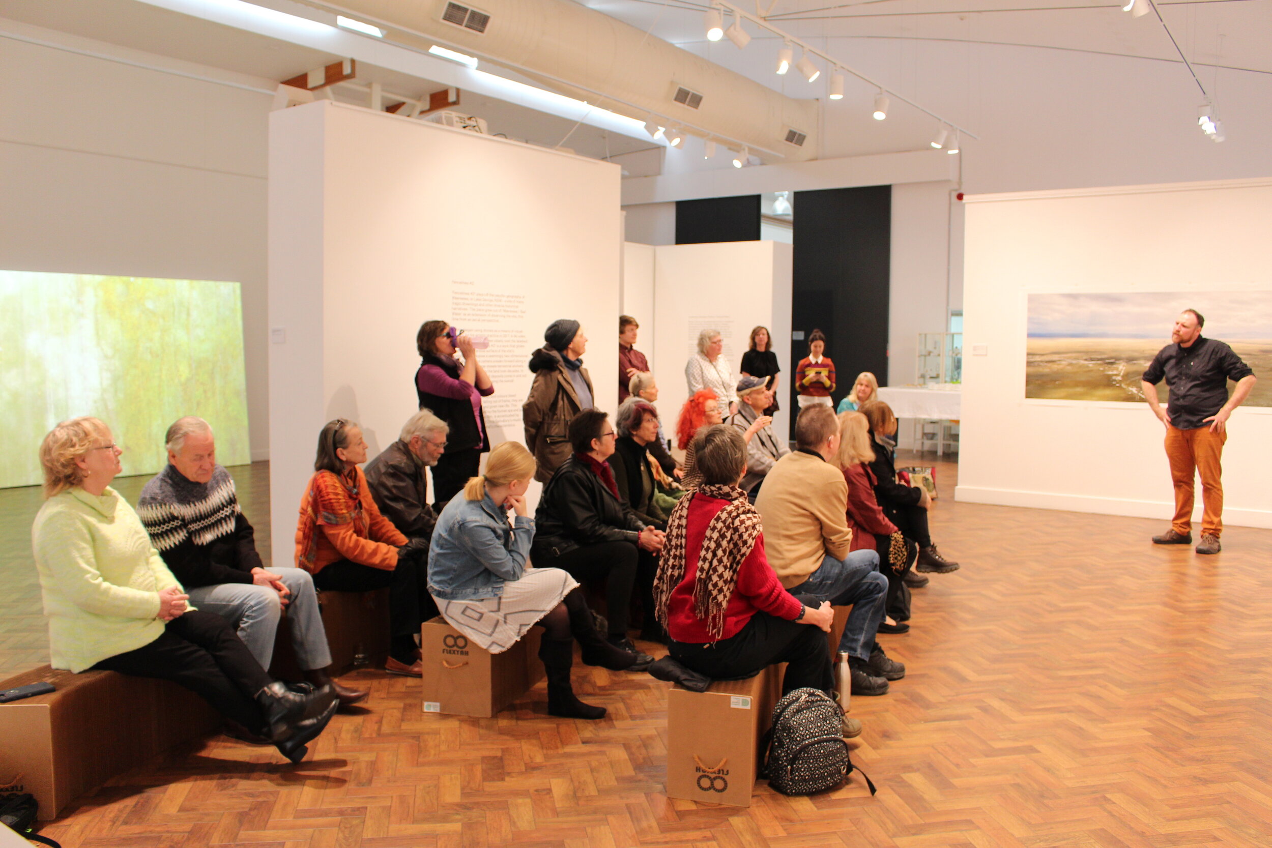  Floor talk by artist  Rowan Conroy  at his solo exhibition  Sighteeing,  held at  Goulburn Regional Art Gallery , 2019.  The works and video installation visible in the photo are by the artist. Photo: Courtesy Goulburn Regional Art Gallery. 