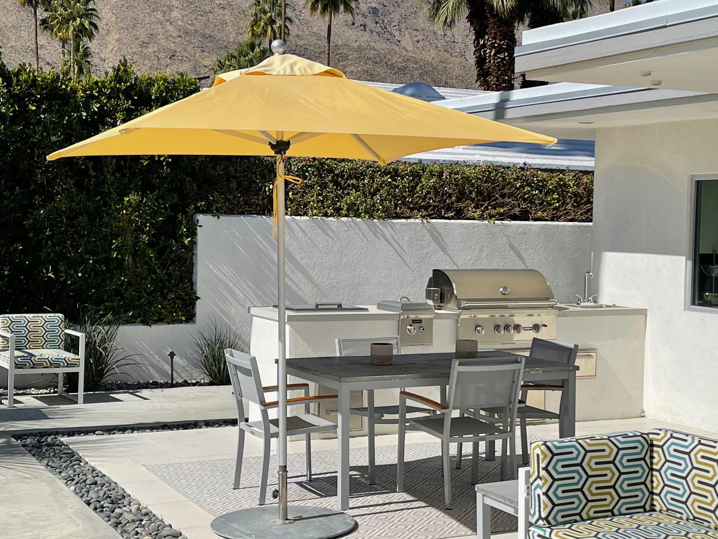 Modern architectural home with resort-like patio and fully-equipped outdoor kitchen, custom upholstered patio lounge chairs, for indoor outdoor living in California desert style by Palm Springs interior designer Michael Bourque.