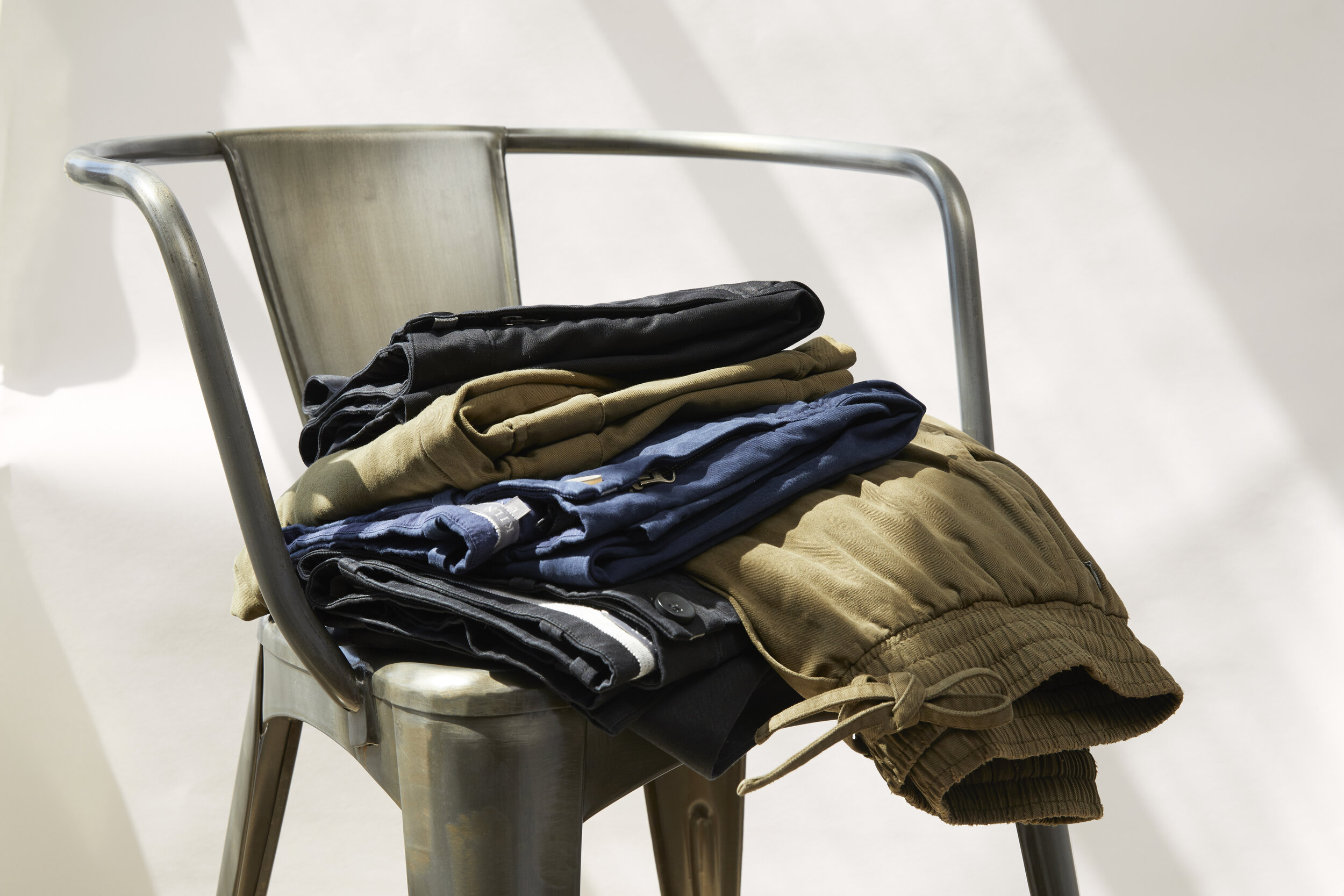 Multiple Folded Pants  on a Metal Chair