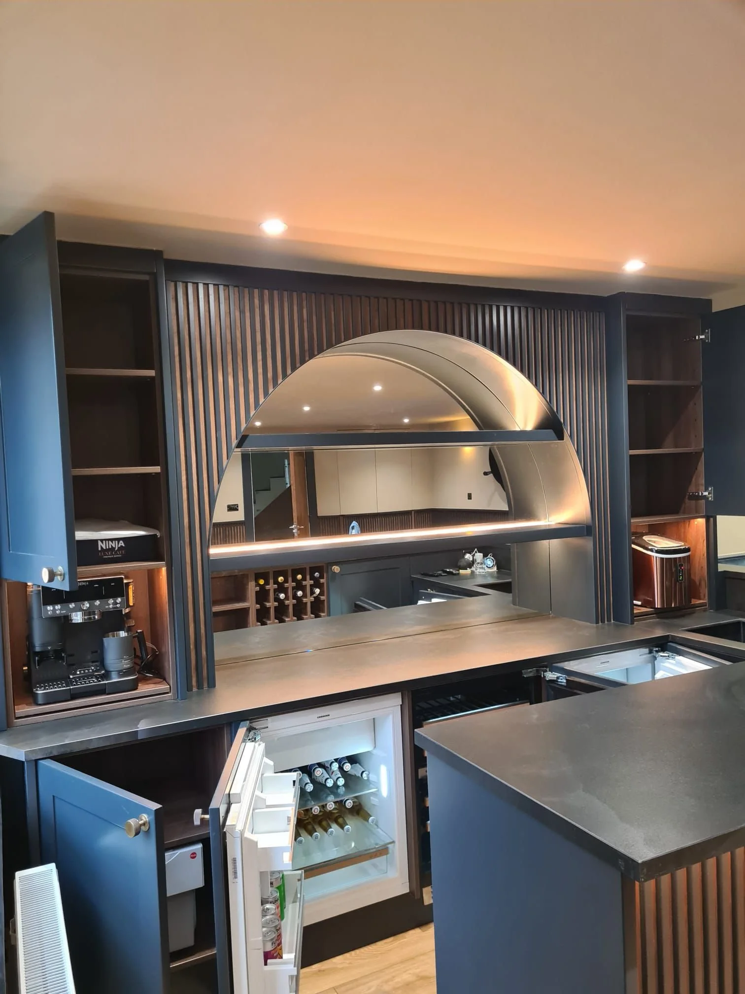 Stunning curved back bar lit with warm white LEDs. Loads of storage and integrated coffee and ice machines. 