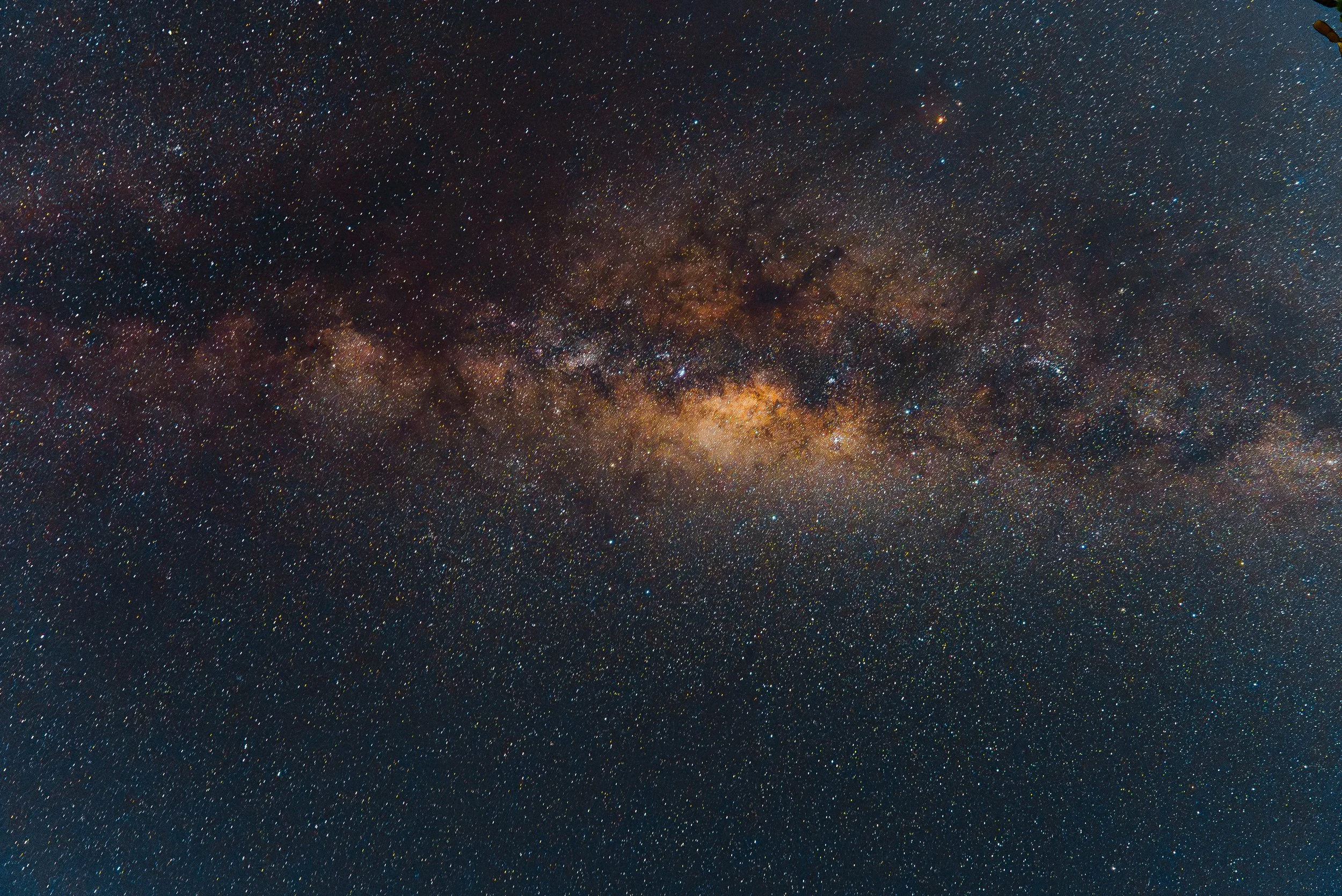 A clear view of the Milky Way galaxy in the night sky, showing a dense band of stars and cosmic dust.