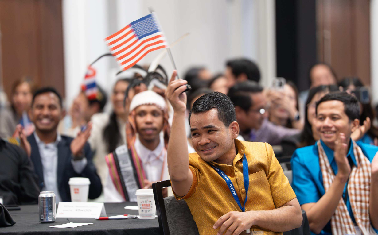 People sitting at tables waving American flags.