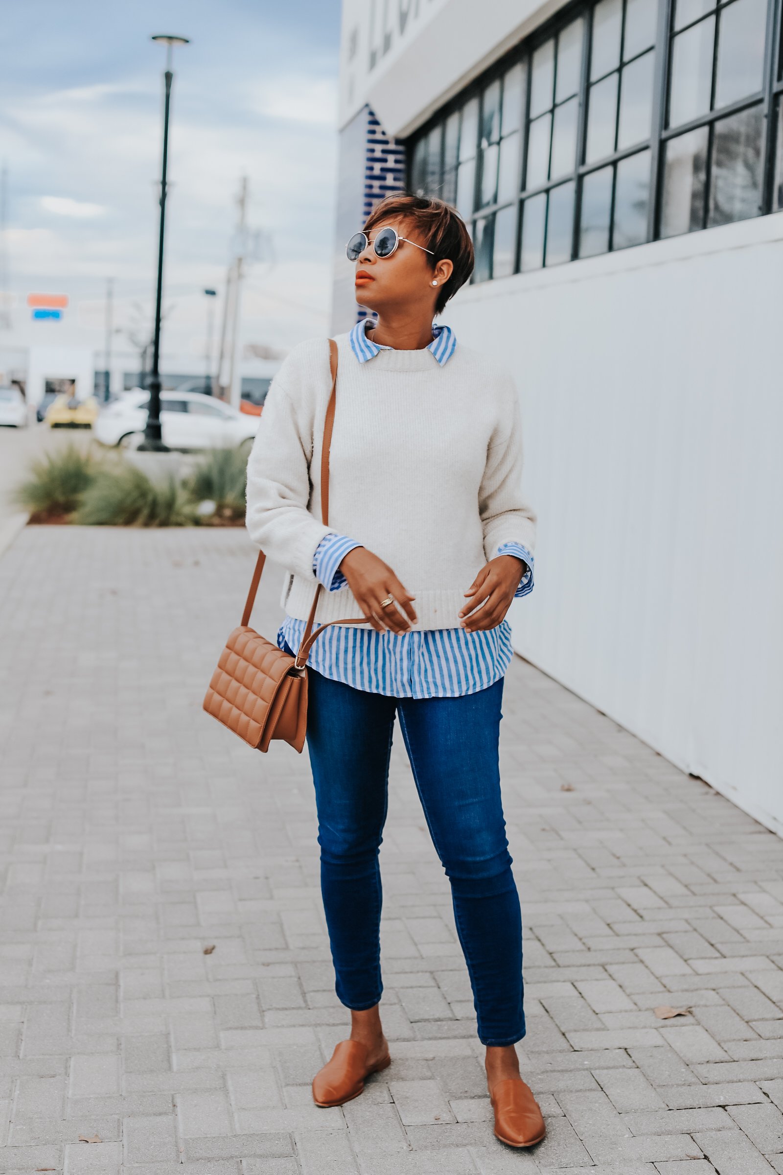 Mary's Little Way in A White Crewneck Sweater, a Blue and White Striped Boyfriend Shirt, Blue Jeans, and Tan Mules