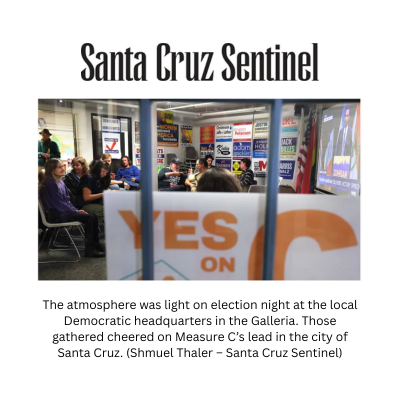 A photo of people inside the Santa Cruz Democratic HQ, with a Yes on C sign in the foreground.