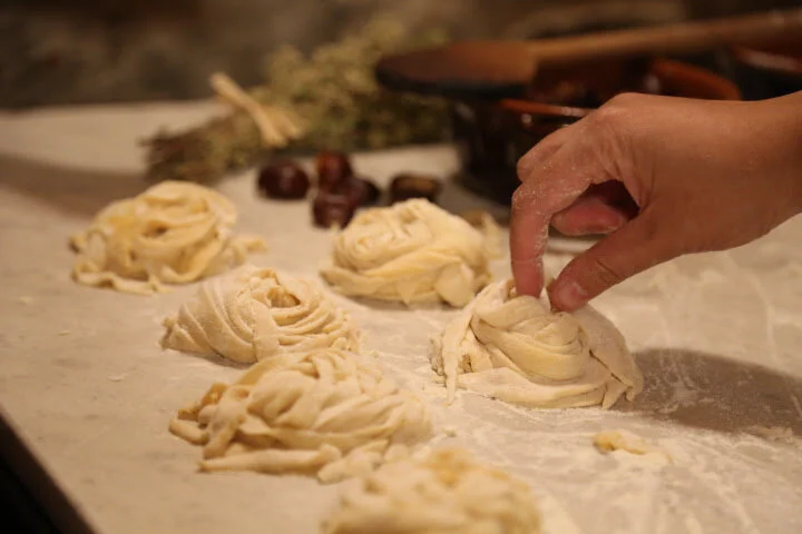 Person preparing braided dough in Tuscany at Castello di Ristonchi an all-inclusive destination wedding venue in Italy.