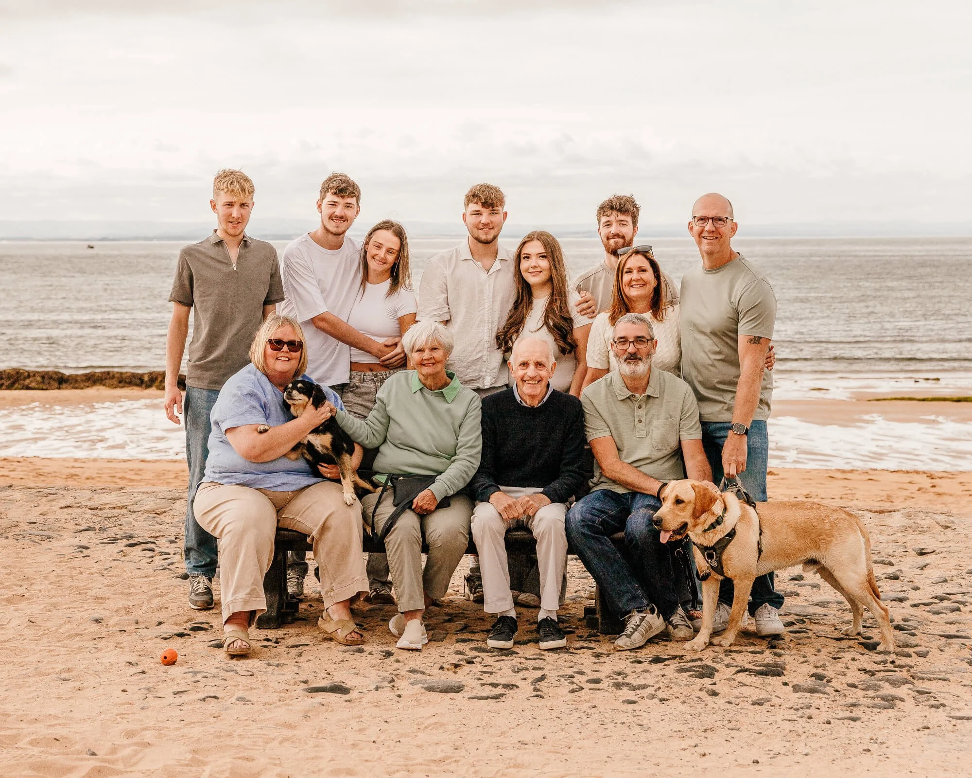 extended family photo at the beach with dogs