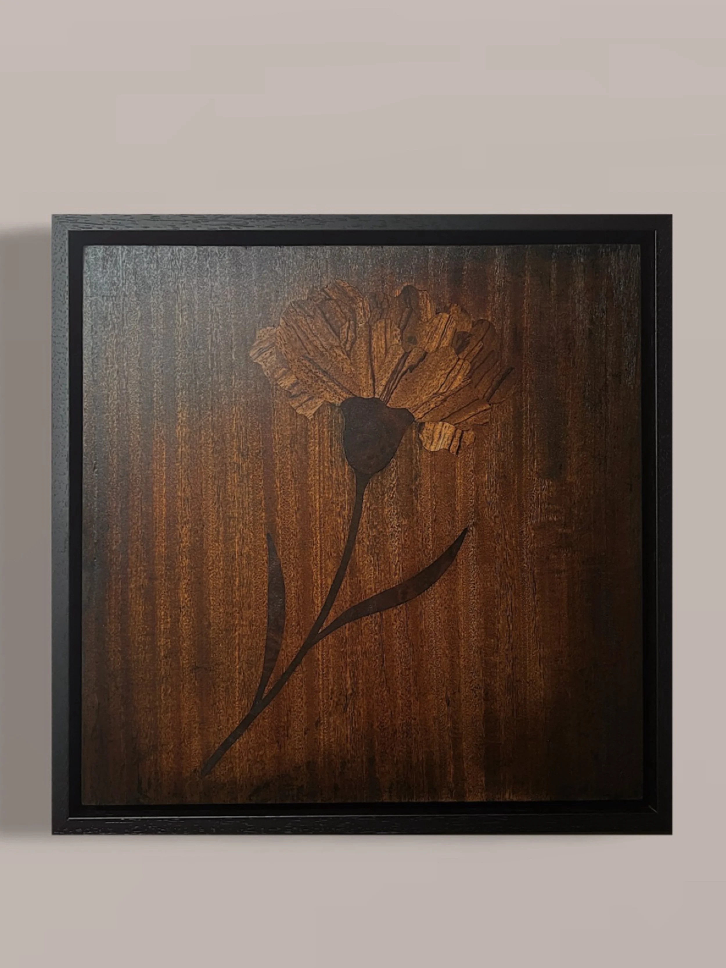Wooden engraved floral marquetry artwork in a black frame