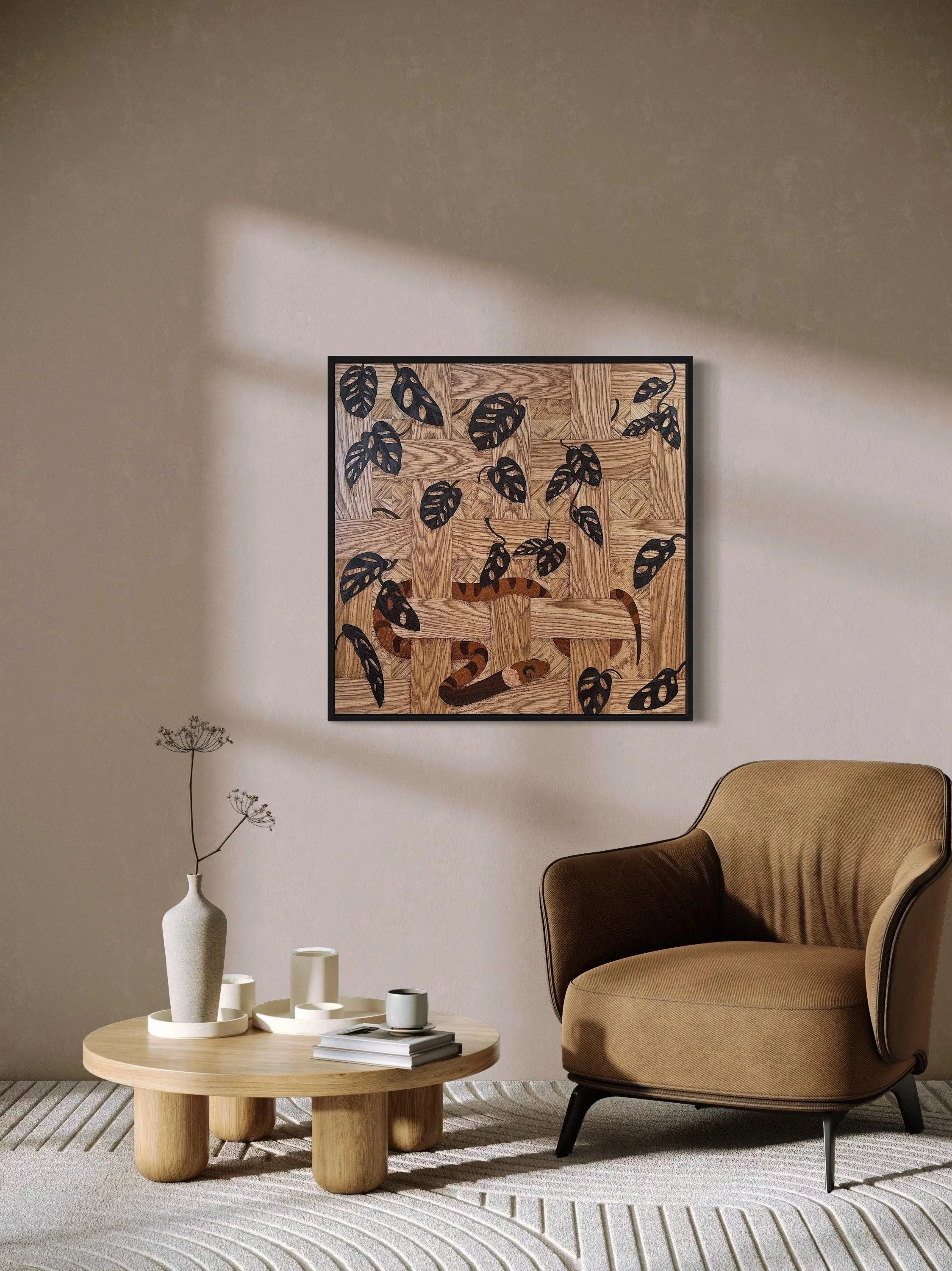 Cozy living room with modern decor; features a brown armchair, round wooden coffee table with decorative vase and books, and a framed marquetry artwork on the wall depicting leaves and camouflaged snake on a wooden pattern background.
