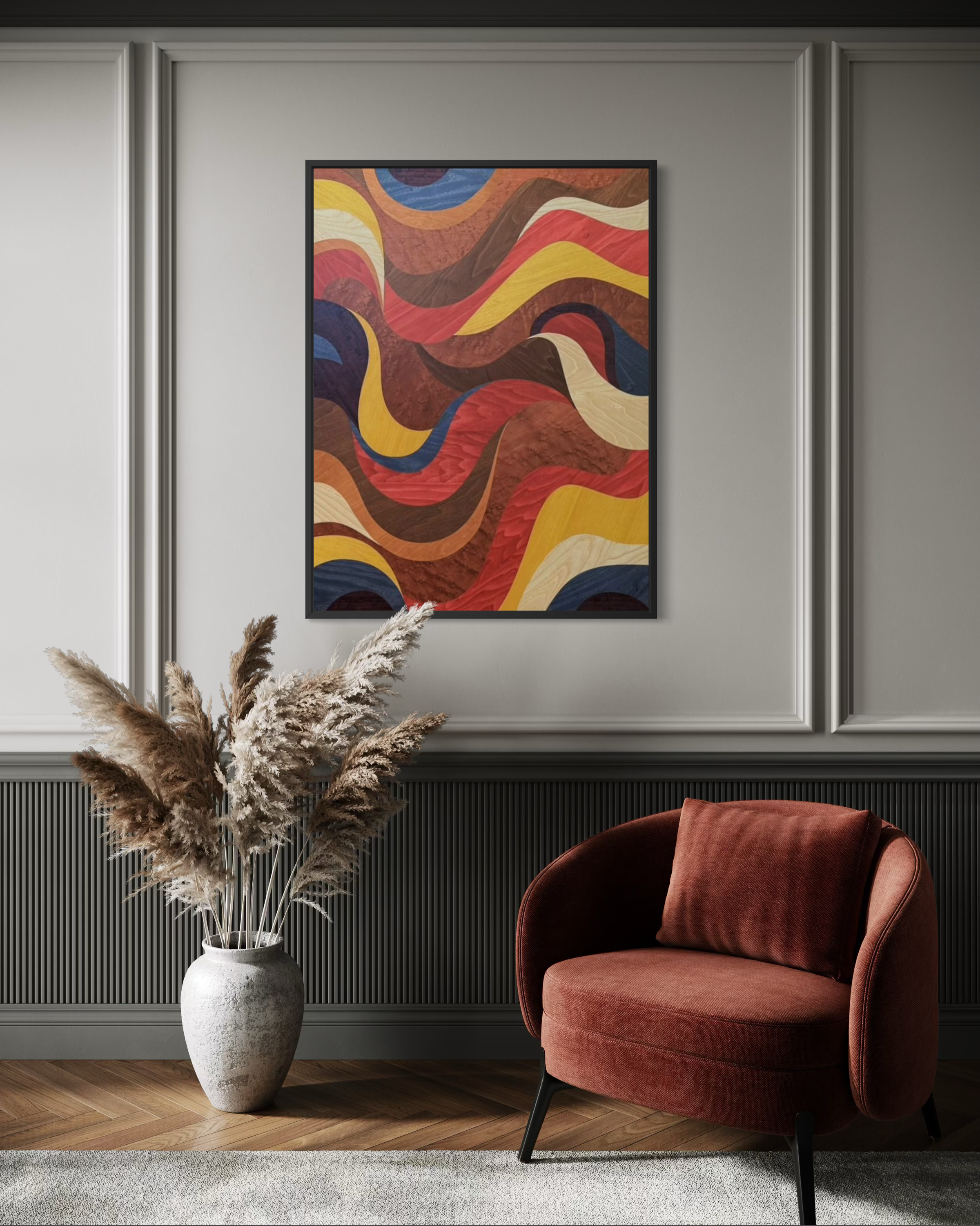 Interior room with a white textured vase holding dried pampas grass, a modern marquetry wall art with colorful abstract flowing patterns, a plush coral-colored armchair with curved design, gray paneled wall, and wooden flooring with carpeted area.