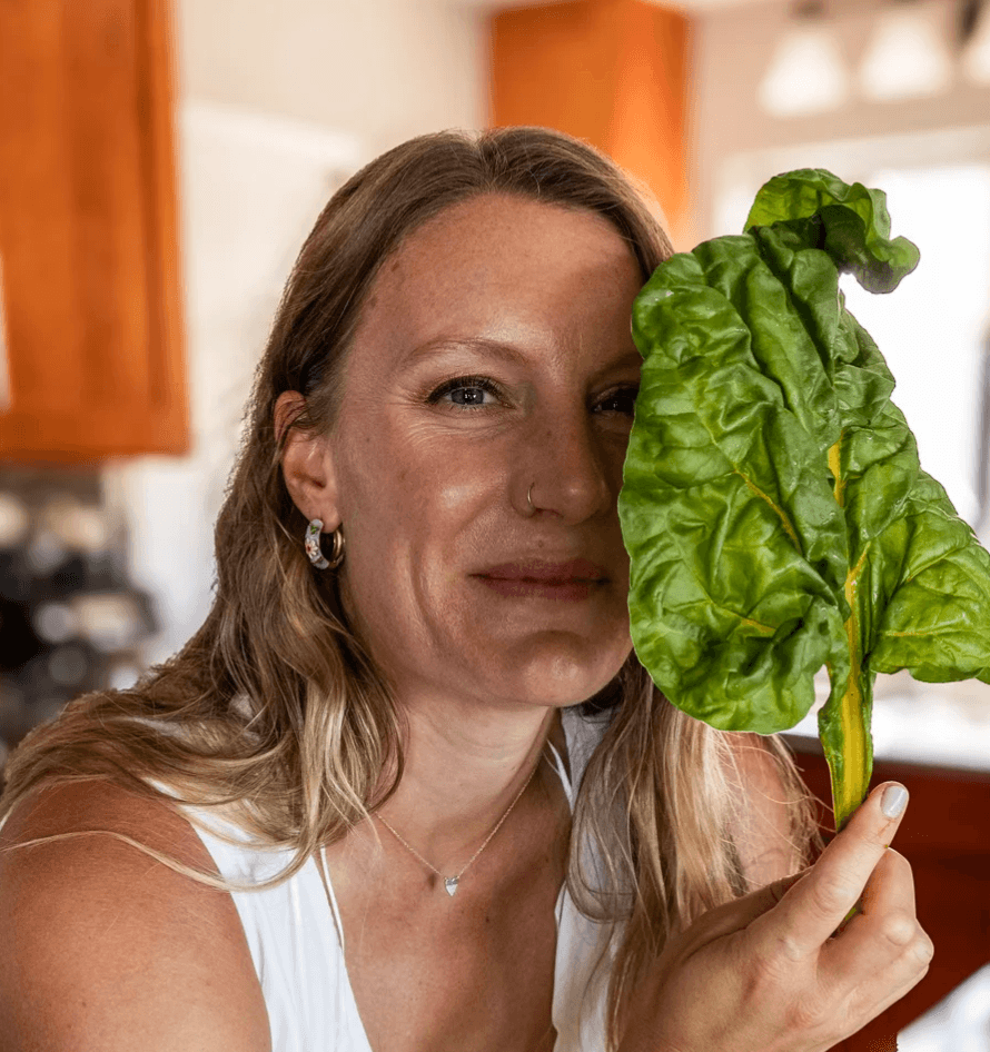 Photo of blonde woman holding lettuce over her one eye