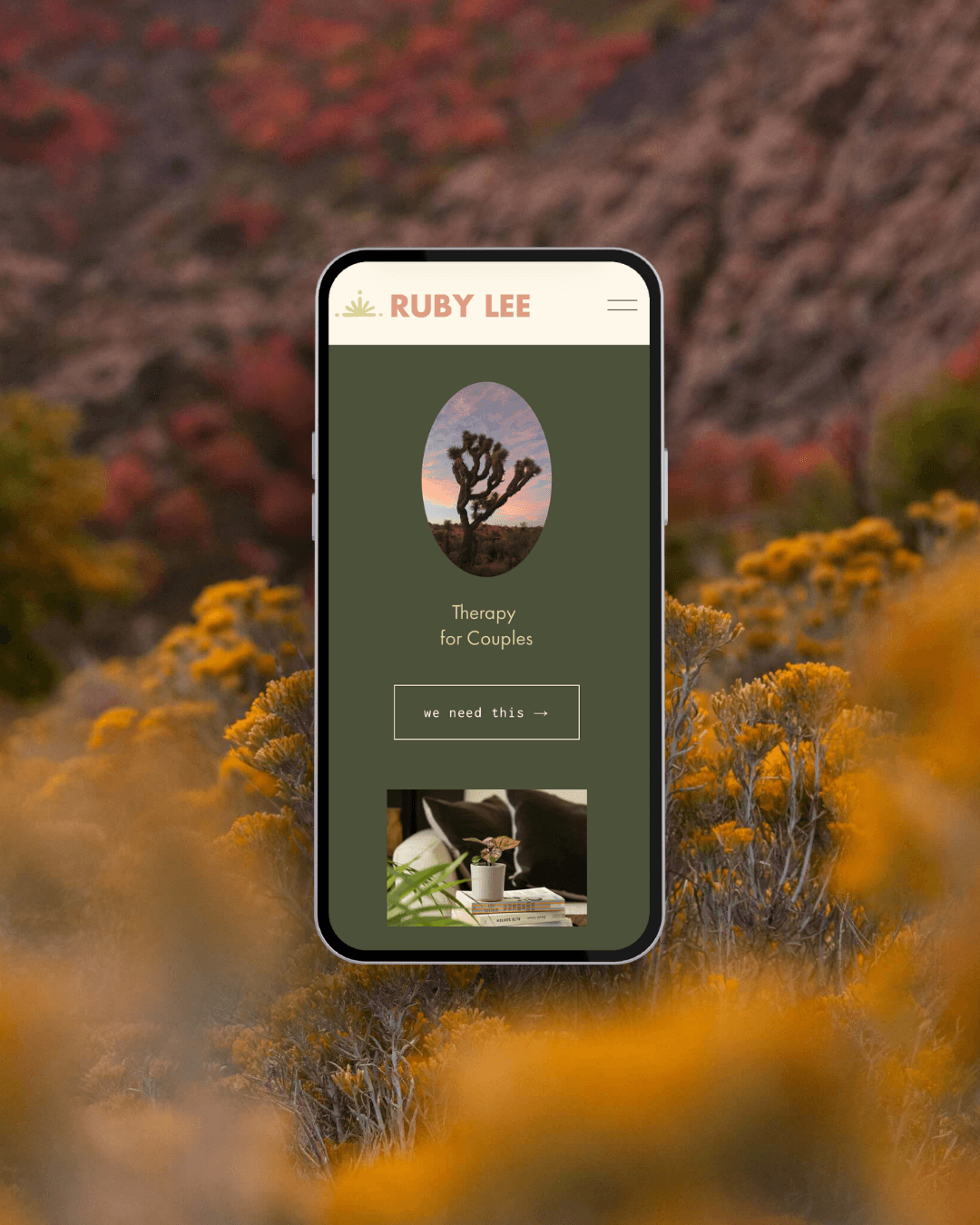 A smartphone with a website for Ruby Lee displaying a desert landscape with a Joshua tree. The site offers therapy for couples with a button labeled 'we need this'. The phone is set against a background of yellow-orange desert wildflowers.