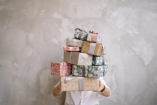 Man carrying an overwhelming stack of gifts, representing love-bombing patterns — Wilson Counseling supports healthy relationships in Bellaire, Texas.