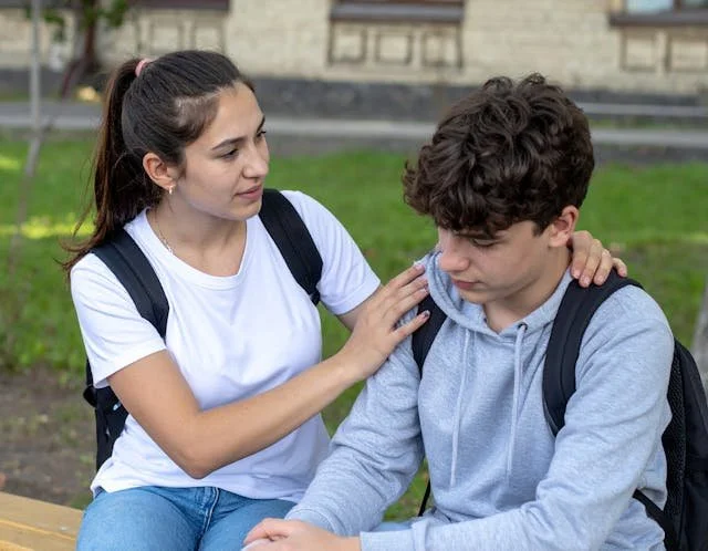 Image of a teenage girl holding her friend who is upset, showing how everyday empathy supports emotional safety. Learn more about empathy skills at Wilson Counseling in Houston.
