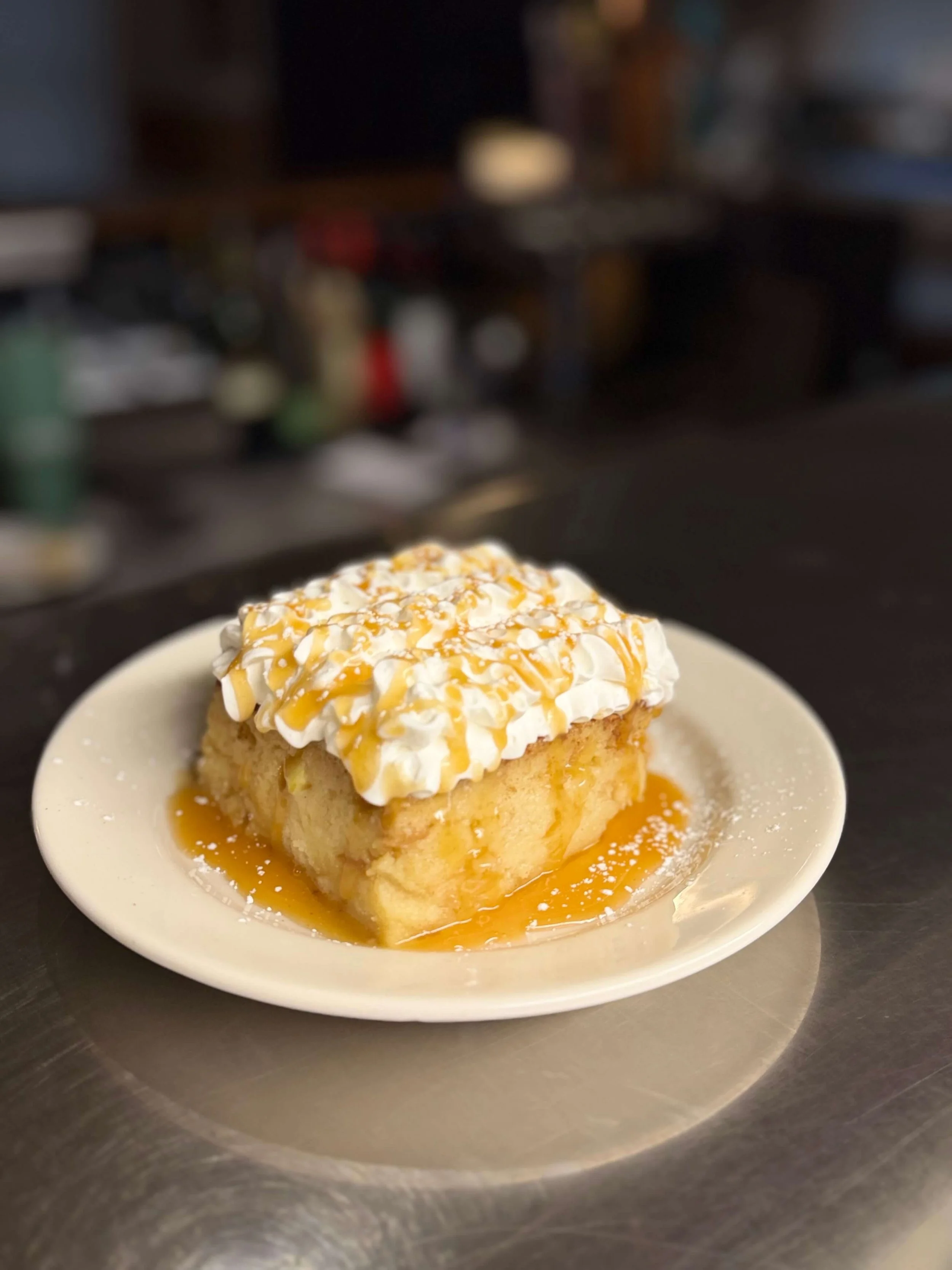 Whipped cream topped authentic Basque dessert cake on a plate