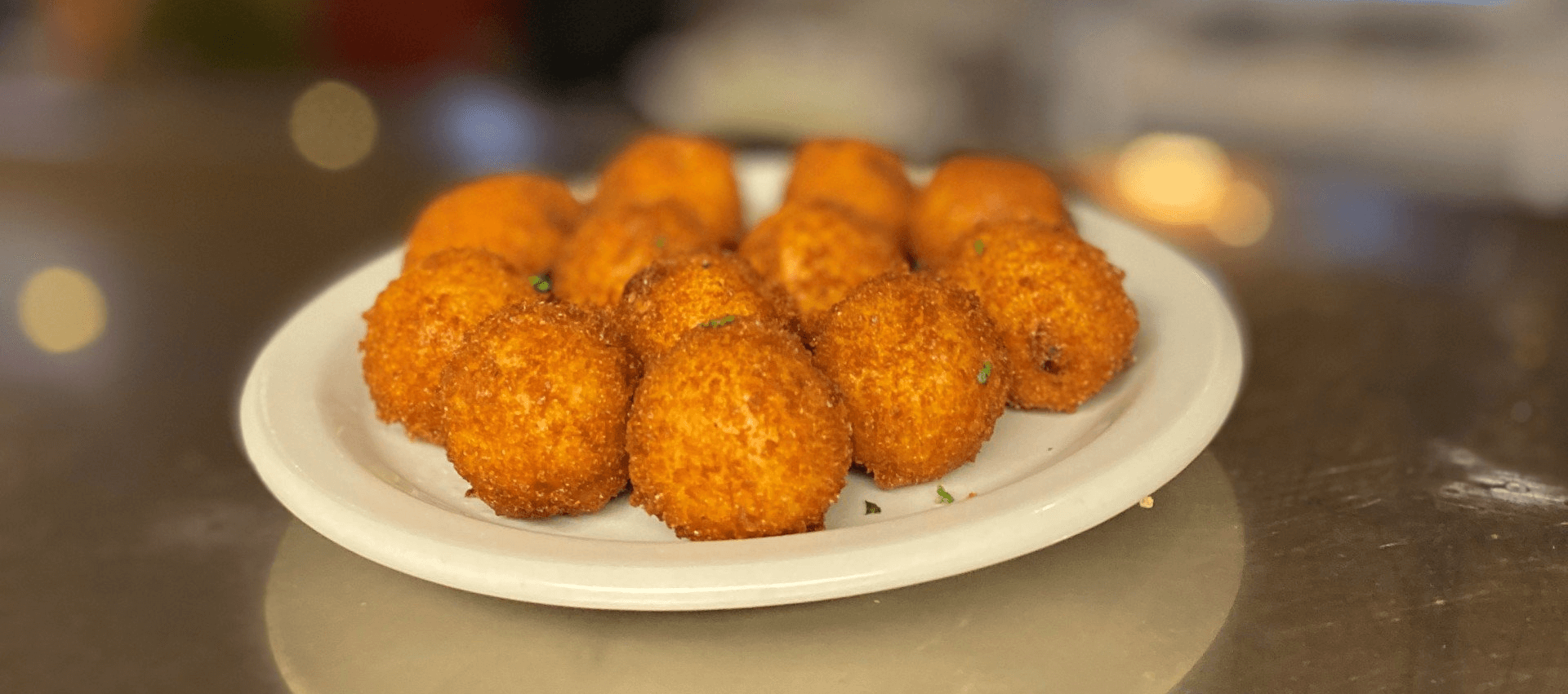 Caption: A full plate of fresh Croquetas, fried golden brown and served hot.