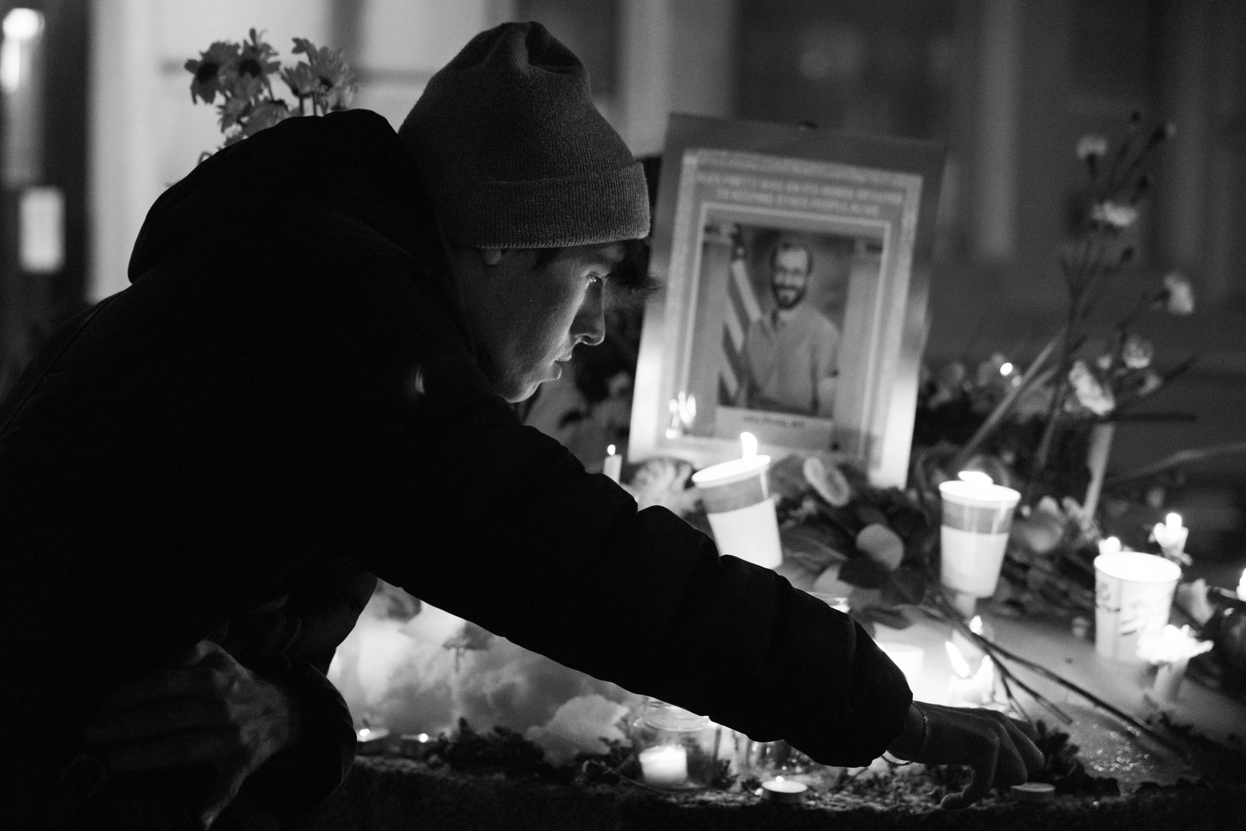 A demonstrator lights a candle at a vigil following the death of Alex Pretti. Pretti was shot and killed by ICE officers in Minneaopolis as they attempted to detain him.