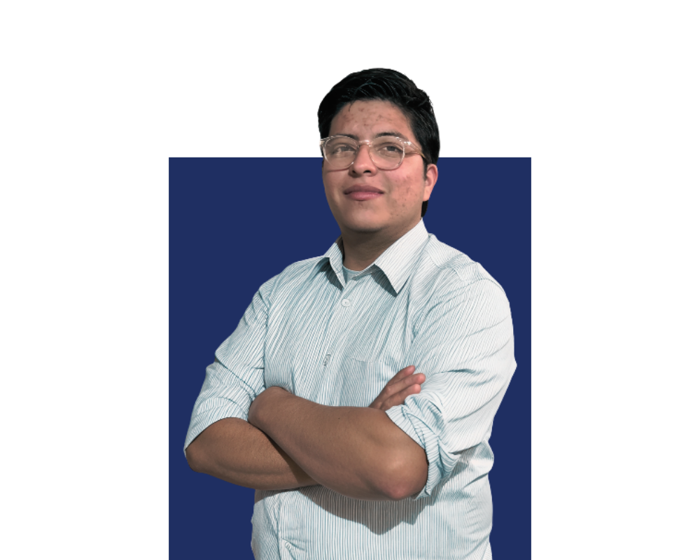 A young man with glasses and black hair wearing a light striped shirt crossing his arms and smiling at the camera against a blue and black background.