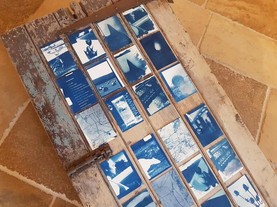 cyanotype prints on an old door from a local cottage tell a story of home and belonging
