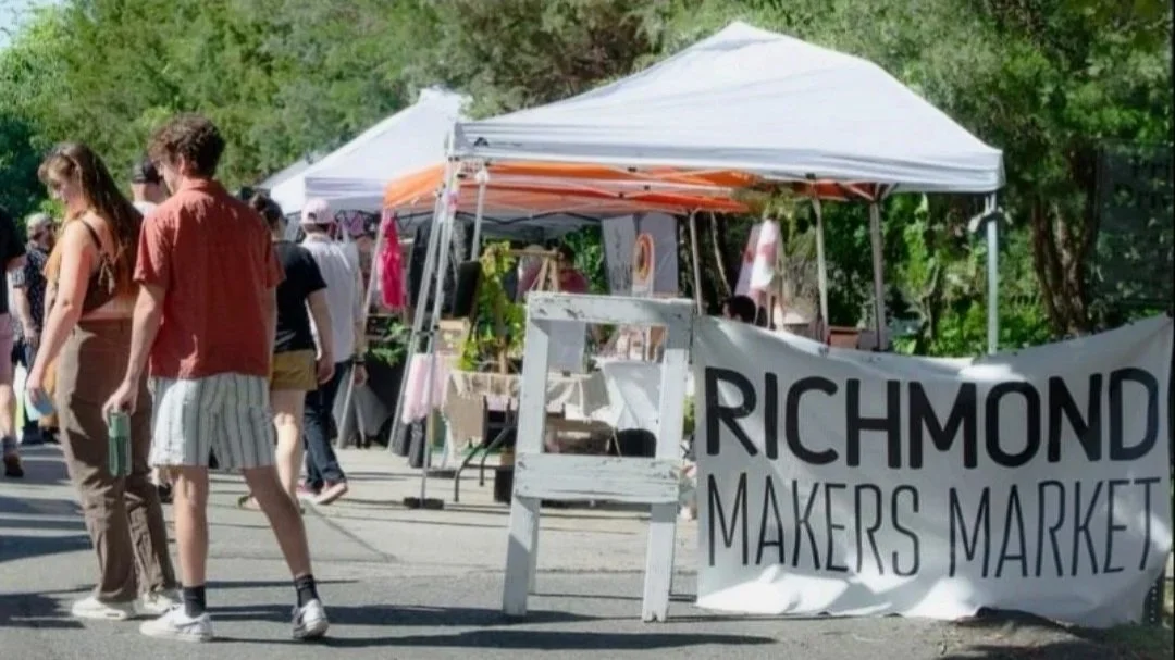 Outdoor market scene with tents, people browsing, and a banner that reads 'Richmond Makers Market'.