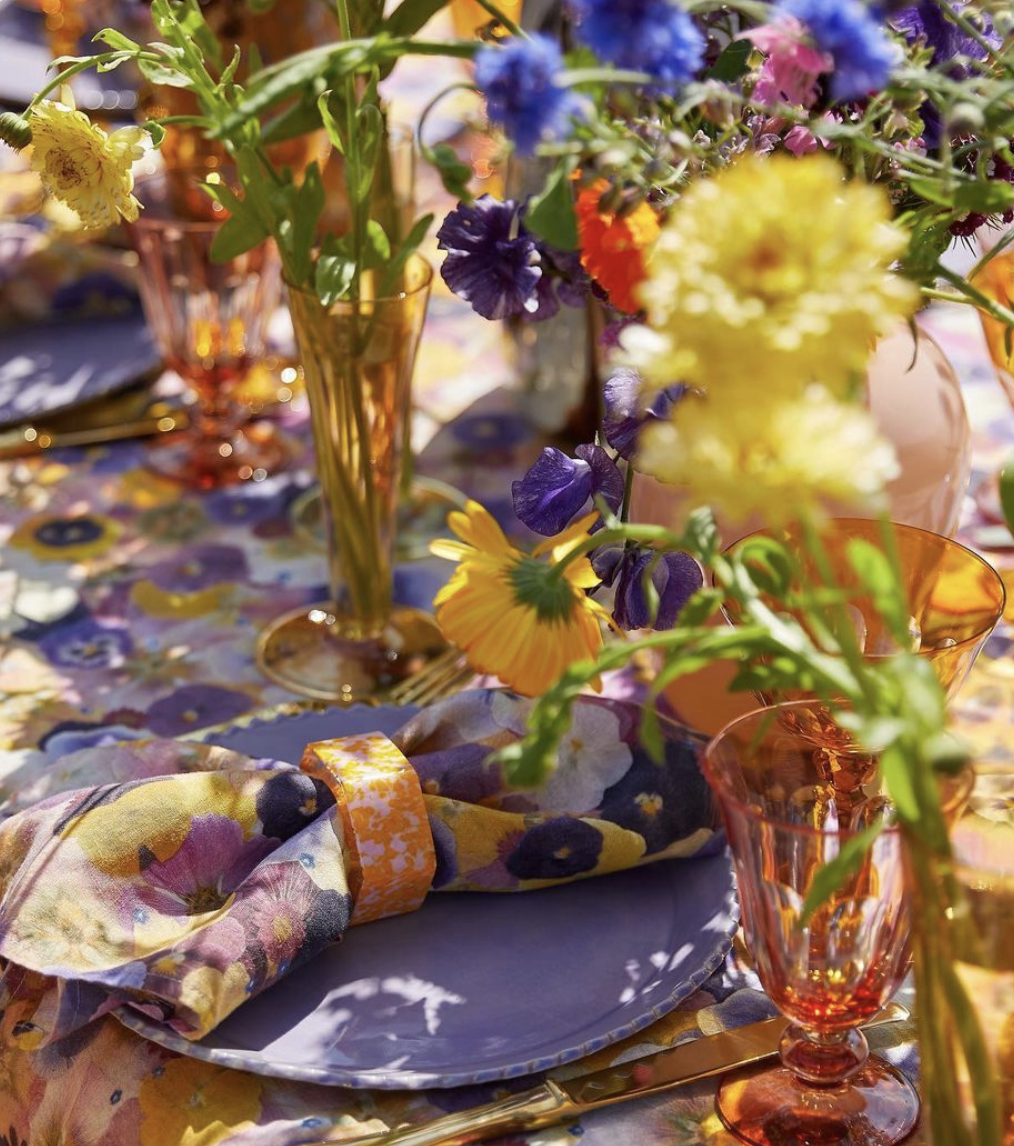 Colorful spring table setting with flowers and glassware