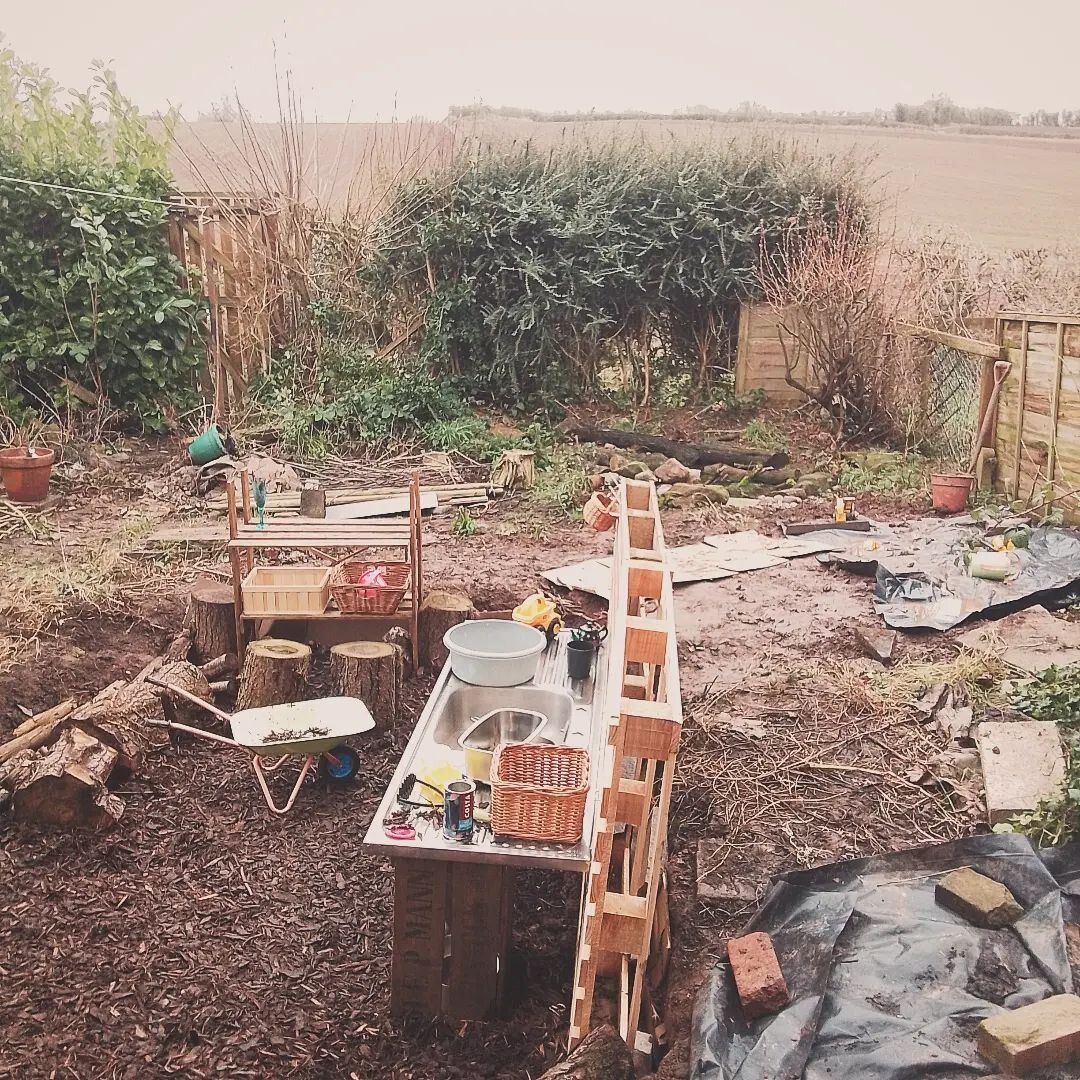 The old pond/swamp/swampost/bottomless pit of despair is now a &quot;play-hole&quot;!
.
Image description: A large dip in the middle of the garden filled with bark chippings, logs and a mud kitchen. There's a wildlife pond and general messy garden in