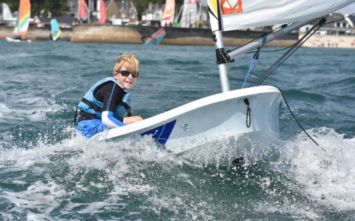 A young sailor in an Optimist dinghy during a course at Yacht Club Carnac