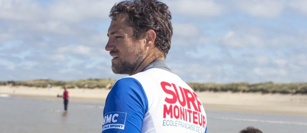 Qualified surf instructor wearing a ‘Surf Moniteur’ Lycra top on Plouharnel beach