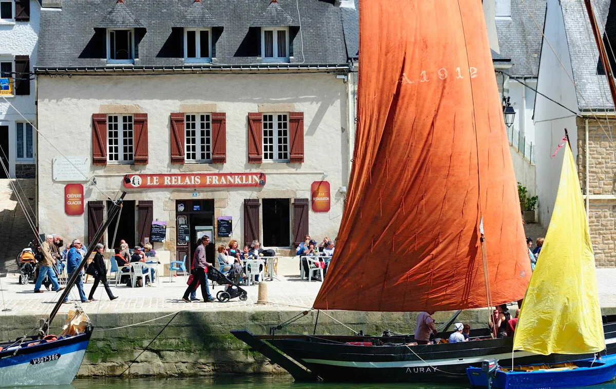 Voiliers traditionnels aux voiles rouge et jaune devant le Relais Franklin, port de Saint-Goustan à Auray
