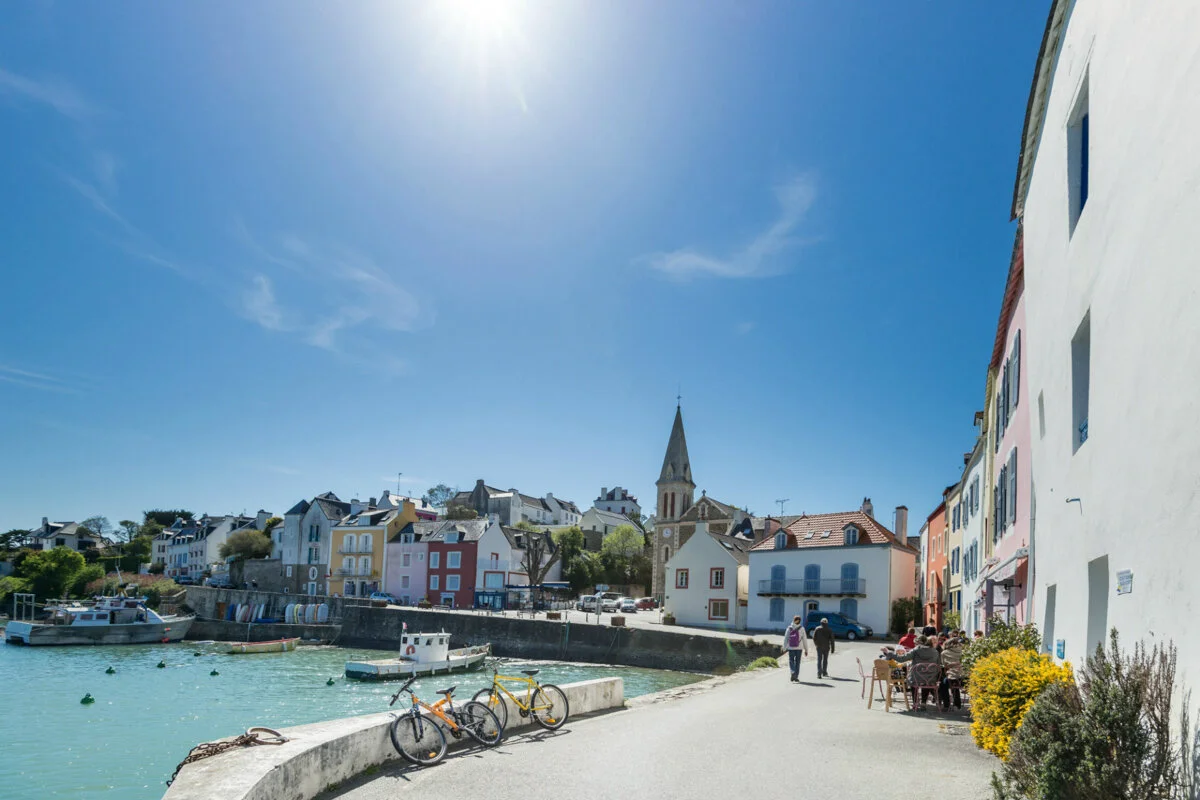 White houses and the bell tower of the village of Houat, overlooking the harbour, bathed in sunlight
