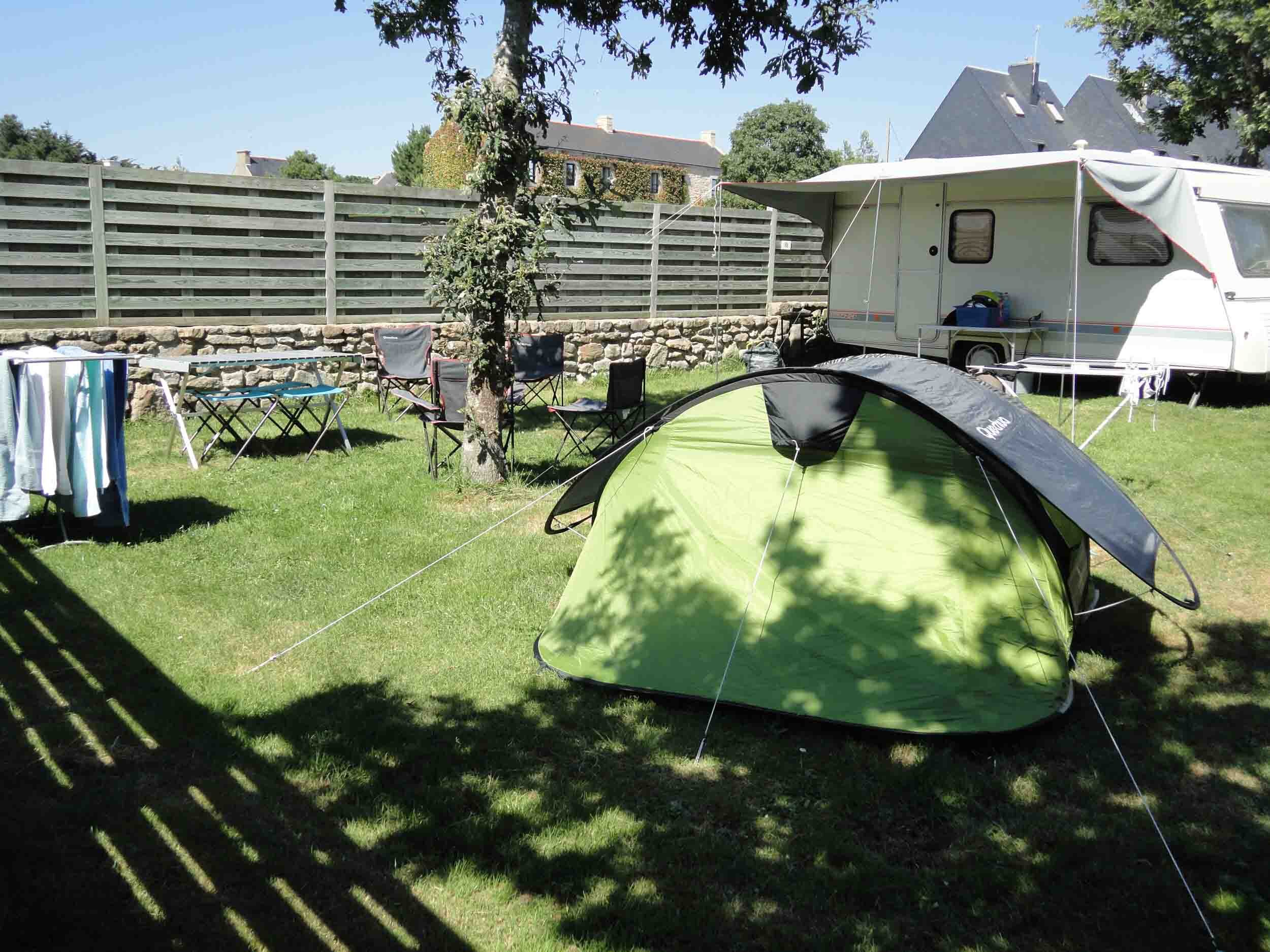 Standaardplaats met tent en caravan onder de bomen op Camping Les Druides in Carnac