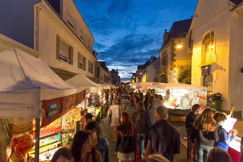 Summer night market on a street in Carnac at dusk