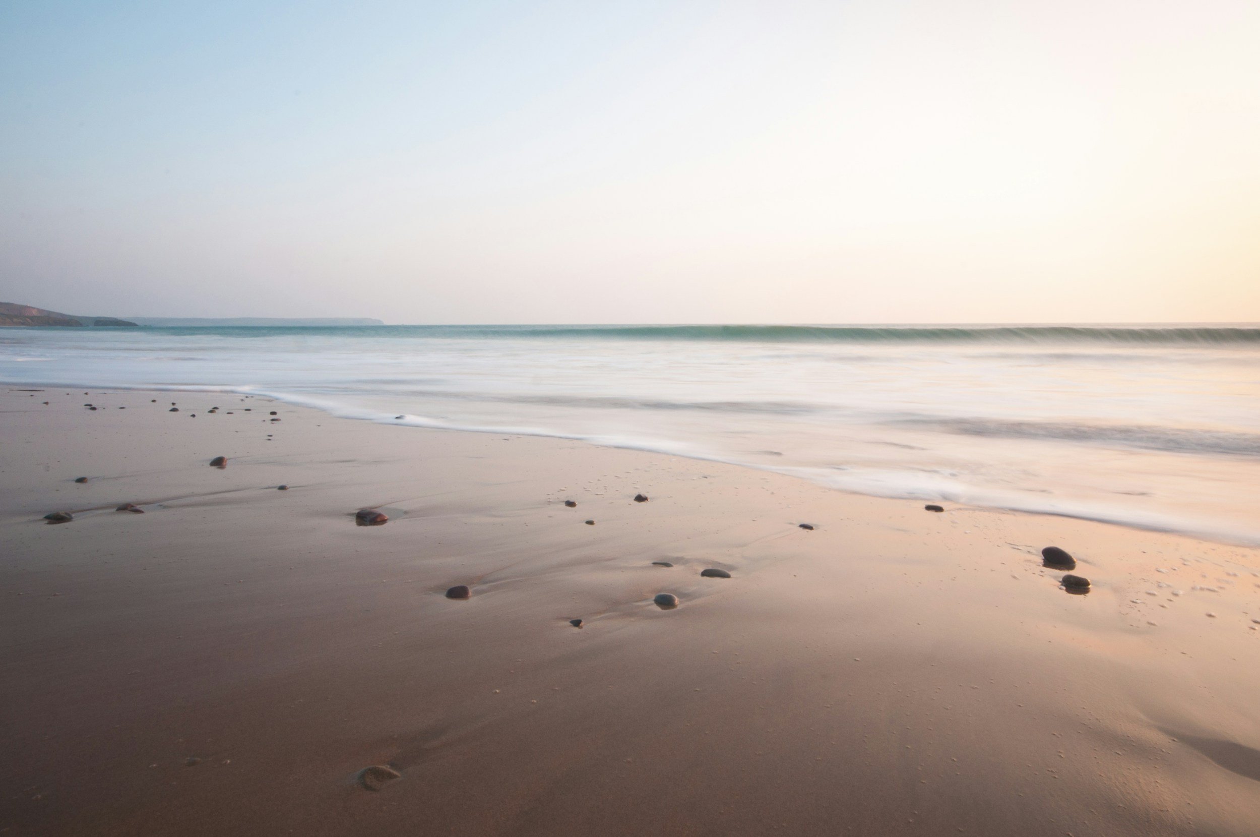 A sandy beach at low tide at sunset, pebbles and waves, Quiberon Bay near Carnac