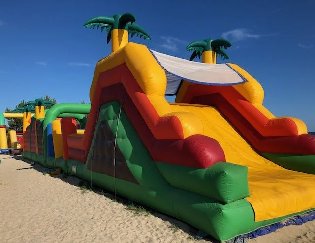Inflatable water slide with palm trees at Club Plage Neptune on the beach at Carnac